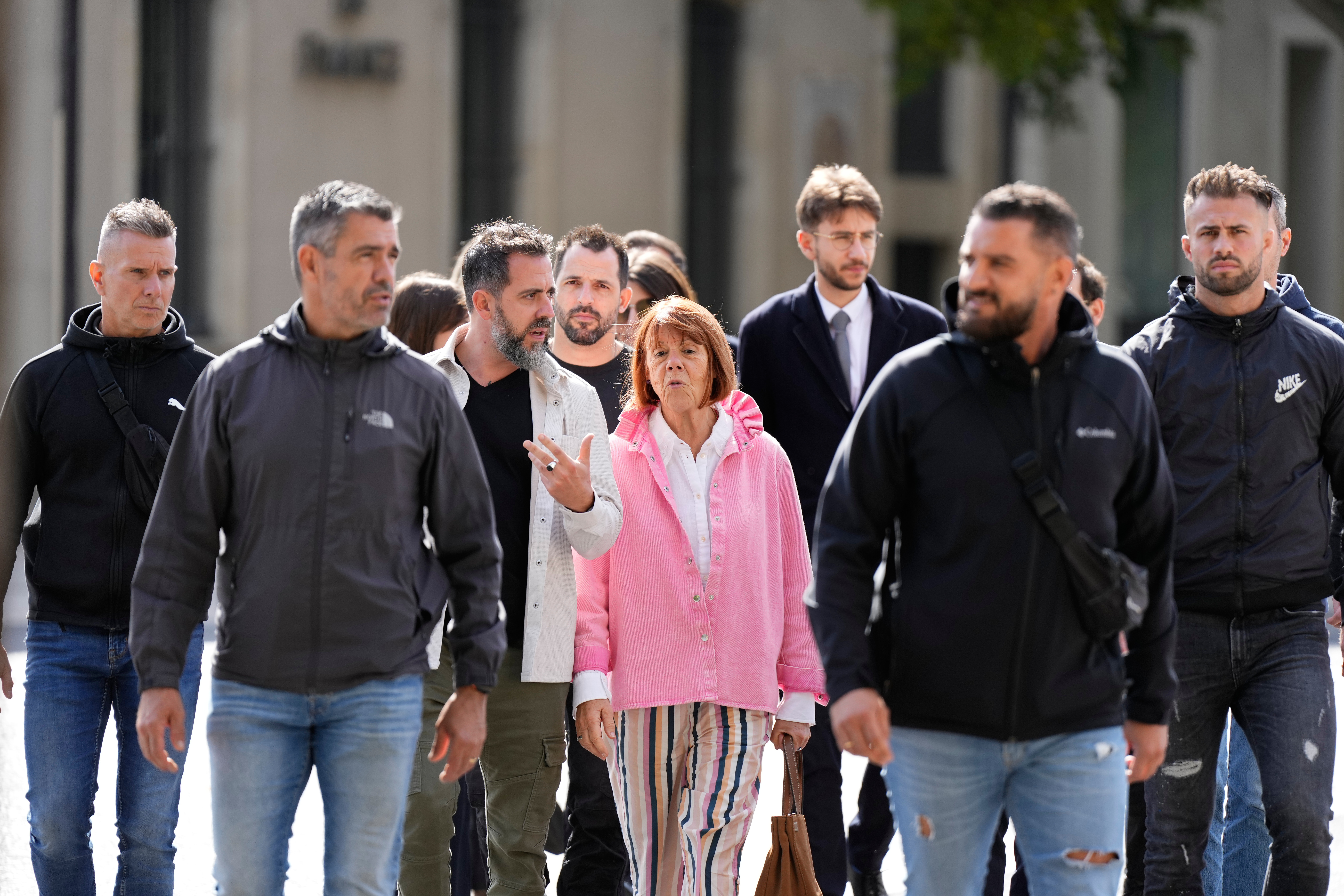 Gisele Pelicot and her son Florian Pelicot, third left, return to the courthouse during the appeals trial in the case of a man challenging his conviction, less than a year after the landmark verdict in a drugging and rape trial that shook France Thursday, Oct. 9, 2025 in Nimes, southern France. (AP Photo/Lewis Joly)