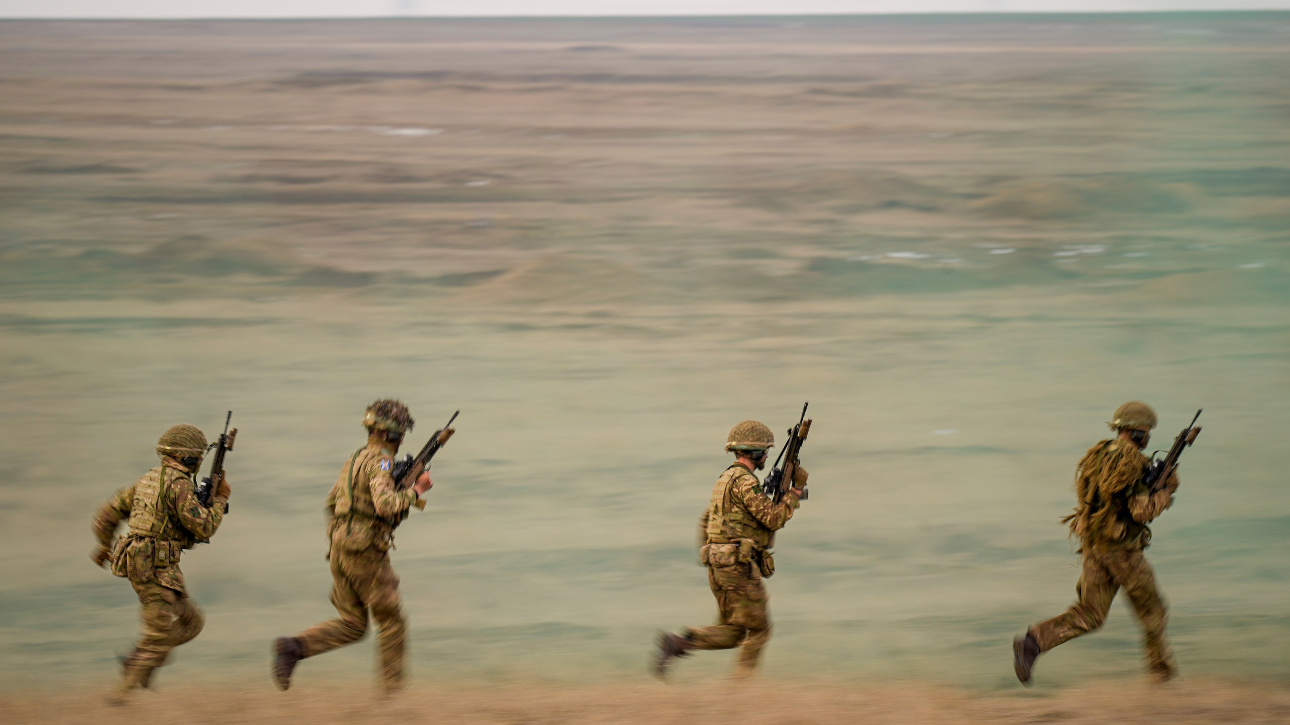FILE- Servicemen run during the Steadfast Dart 2025 exercise, involving some 10,000 troops in three different countries from nine nations, representing the largest NATO operation planned this year, at a training range in Smardan, eastern Romania, Wednesday, Feb. 19, 2025. (AP Photo/Vadim Ghirda, file)