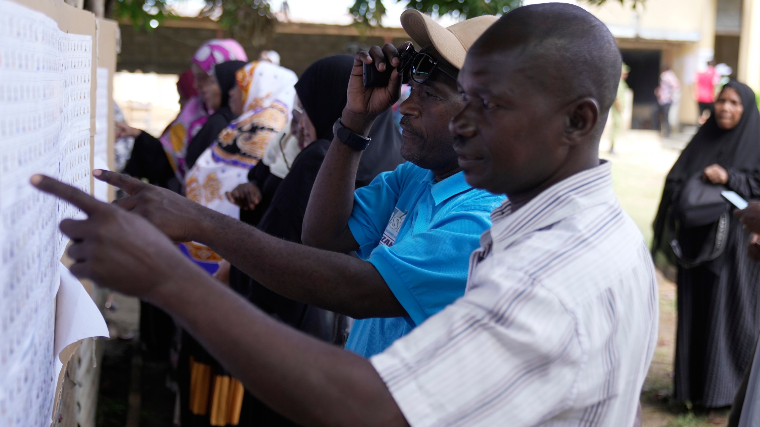 Voters verify their names before voting during the general elections at Mpendaye polling station in Zanzibar, Tanzania, Wednesday, Oct. 29, 2025. (AP Photo/Brian Inganga)
