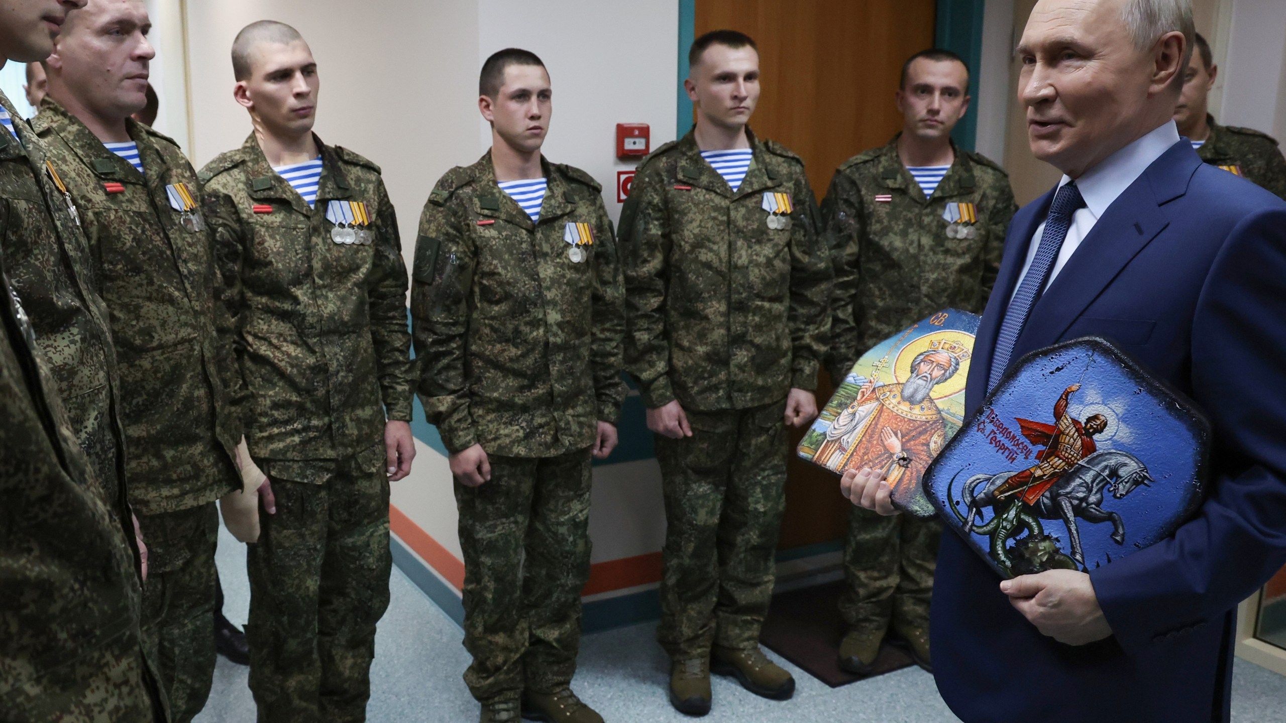 President Vladimir Putin holds Russian Orthodox icons as he meets with soldiers wounded in action in Ukraine, at the the Mandryk Central Military Clinical Hospital, in Moscow, Russia, Wednesday, Oct. 29, 2025. (Vyacheslav Prokofyev, Sputnik, Kremlin Pool Photo via AP)