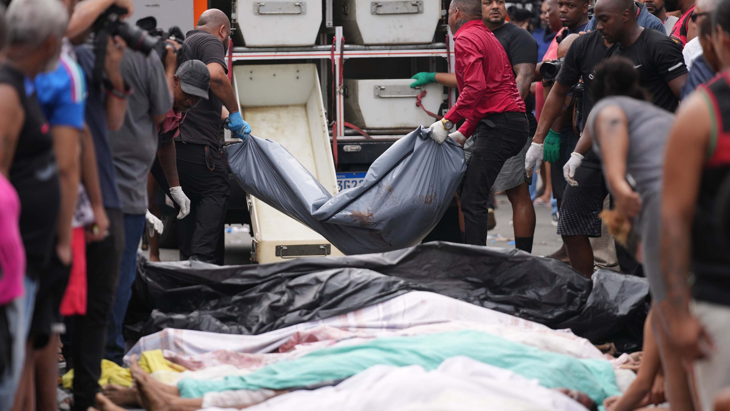 Forensic workers collect the bodies of people killed the day before during a police raid targeting the Comando Vermelho gang in the Complexo da Penha favela of Rio de Janeiro, Brazil, Wednesday, Oct. 29, 2025. (AP Photo/Silvia Izquierdo)