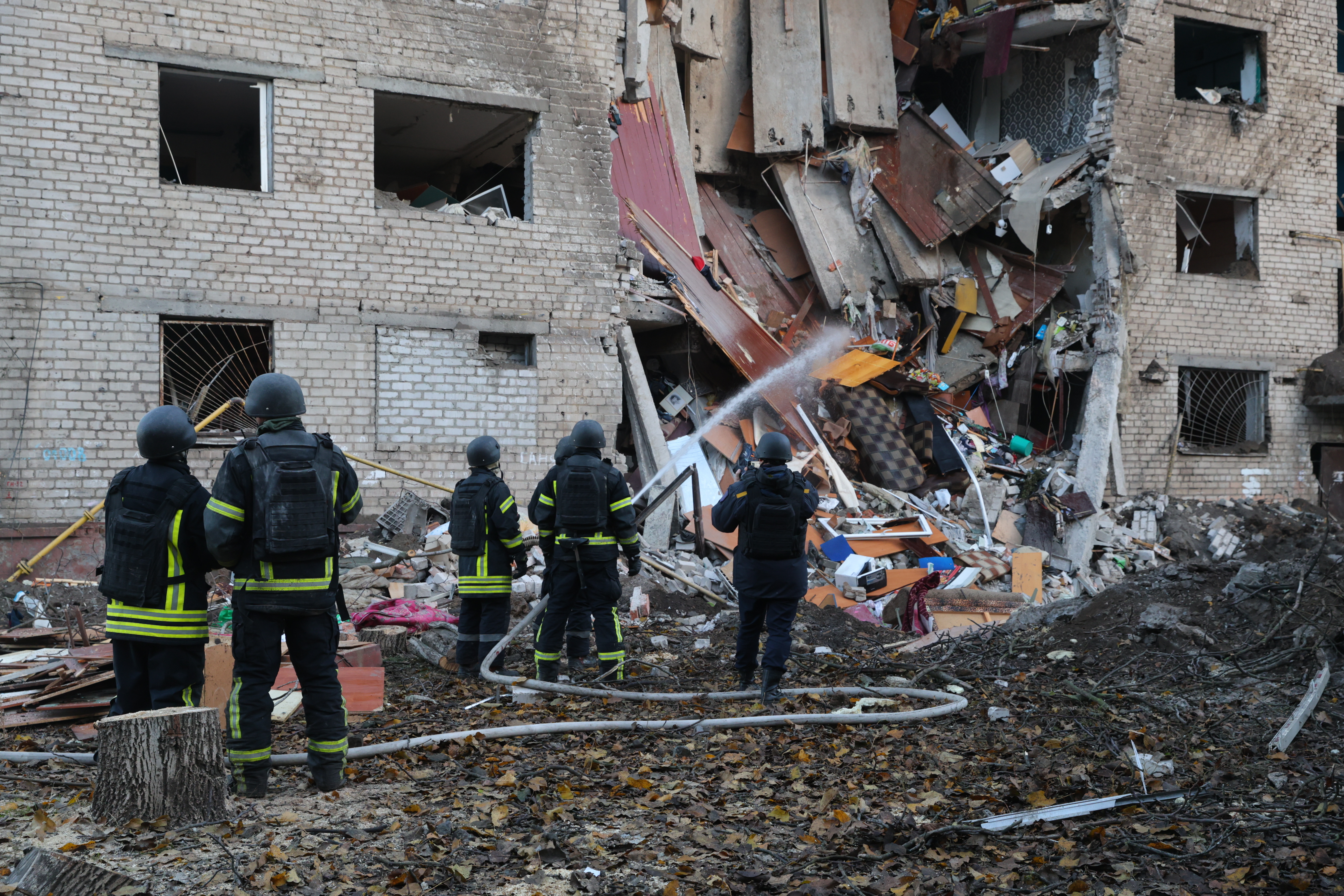 Rescuers attend to the scene after a Russian missile hit a hostel in Zaporizhzhia, Ukraine, Thursday, Oct. 30, 2025. (AP Photo/Kateryna Klochko)