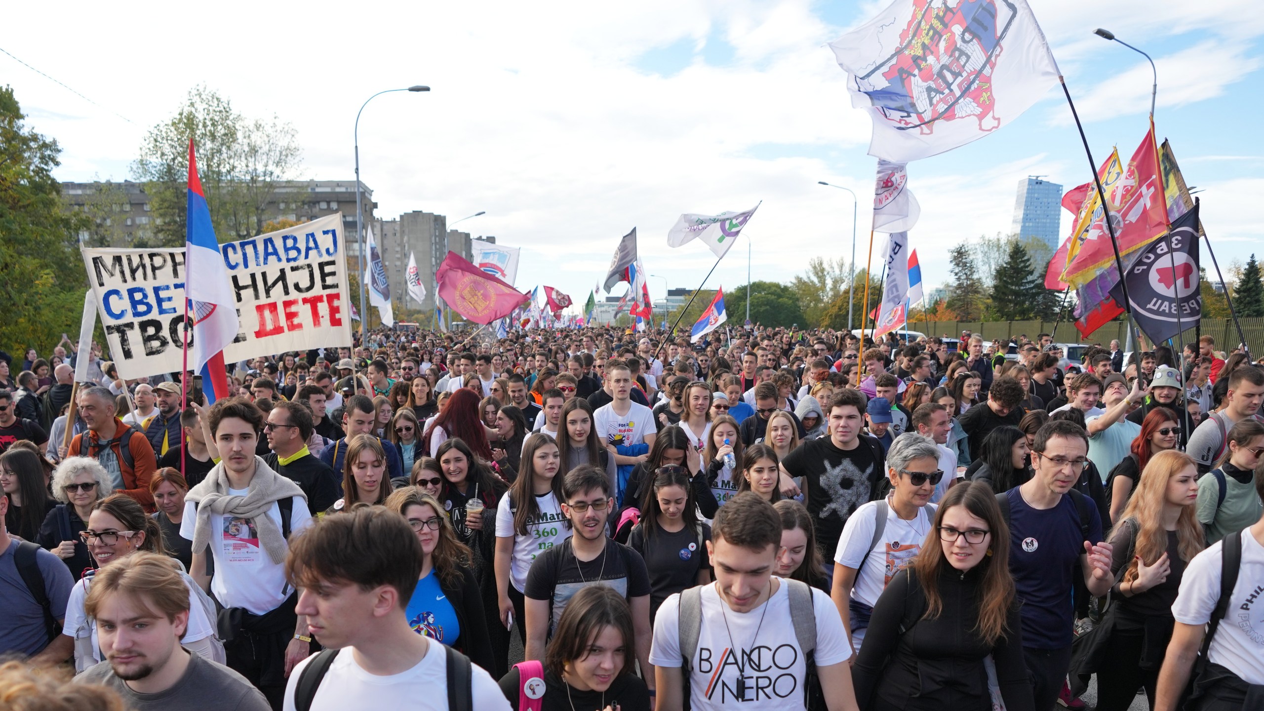 People gather, among them students, to walk on the street towards the northern city of Novi Sad, for a huge rally on Nov. 1 marking the first anniversary of a train station disaster that killed 16 people, in Belgrade, Serbia, Thursday, Oct. 30, 2025. (AP Photo/Darko Vojinovic)