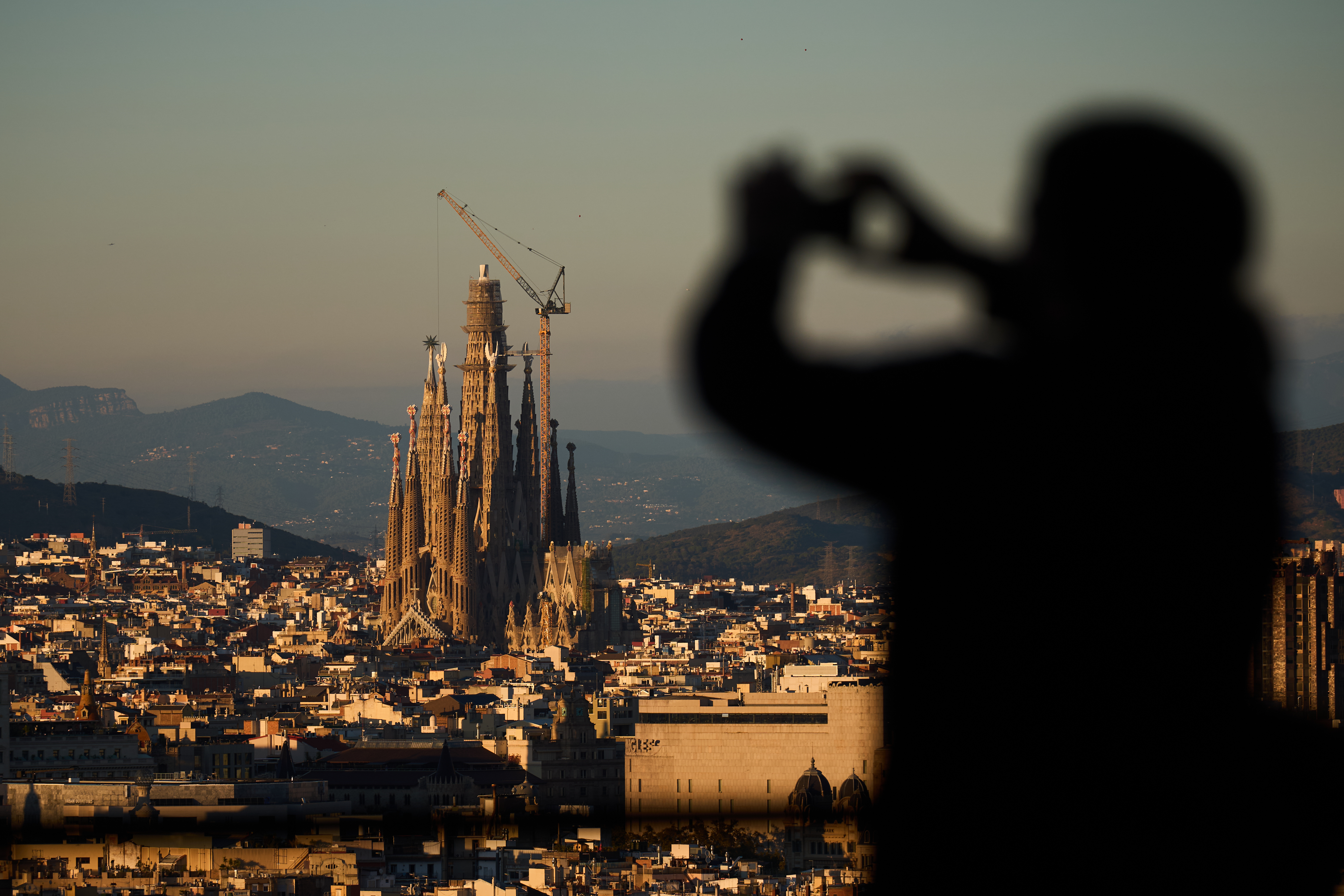 A tourist takes photos at the Sagrada Familia basilica, which became the world's tallest church on Thursday after a section of its central tower was lifted into place, in Barcelona, Spain, Oct. 30, 2025. (AP Photo/Emilio Morenatti)