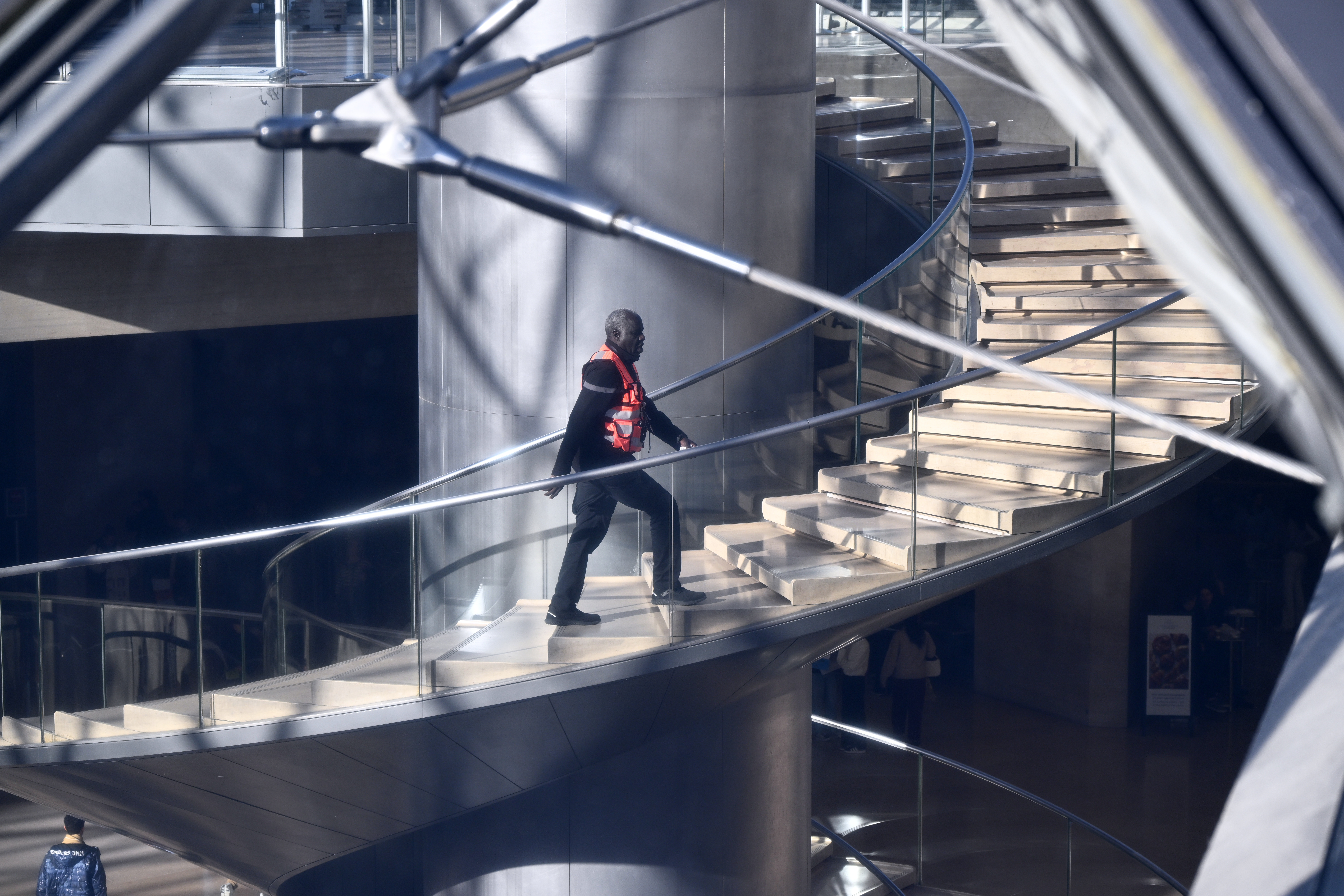 A private member of the security claims up the stairs in the Louvre museum, Thursday, Oct. 30, 2025 in Paris. (AP Photo/Emma Da Silva)