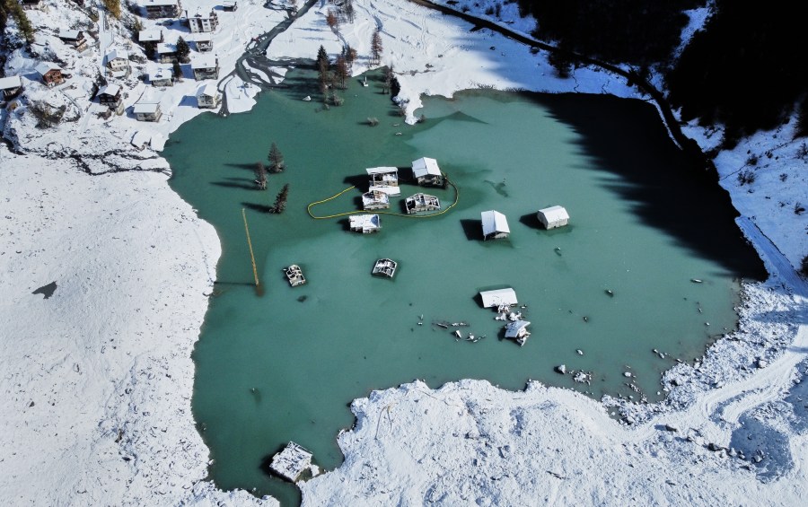 An aerial view shows the partly flooded village of Blatten after recent snowfalls, five months after a landslide destroyed the village, Blatten, Switzerland, on Tuesday, Oct. 28, 2025. (AP Photo/Michael Probst)