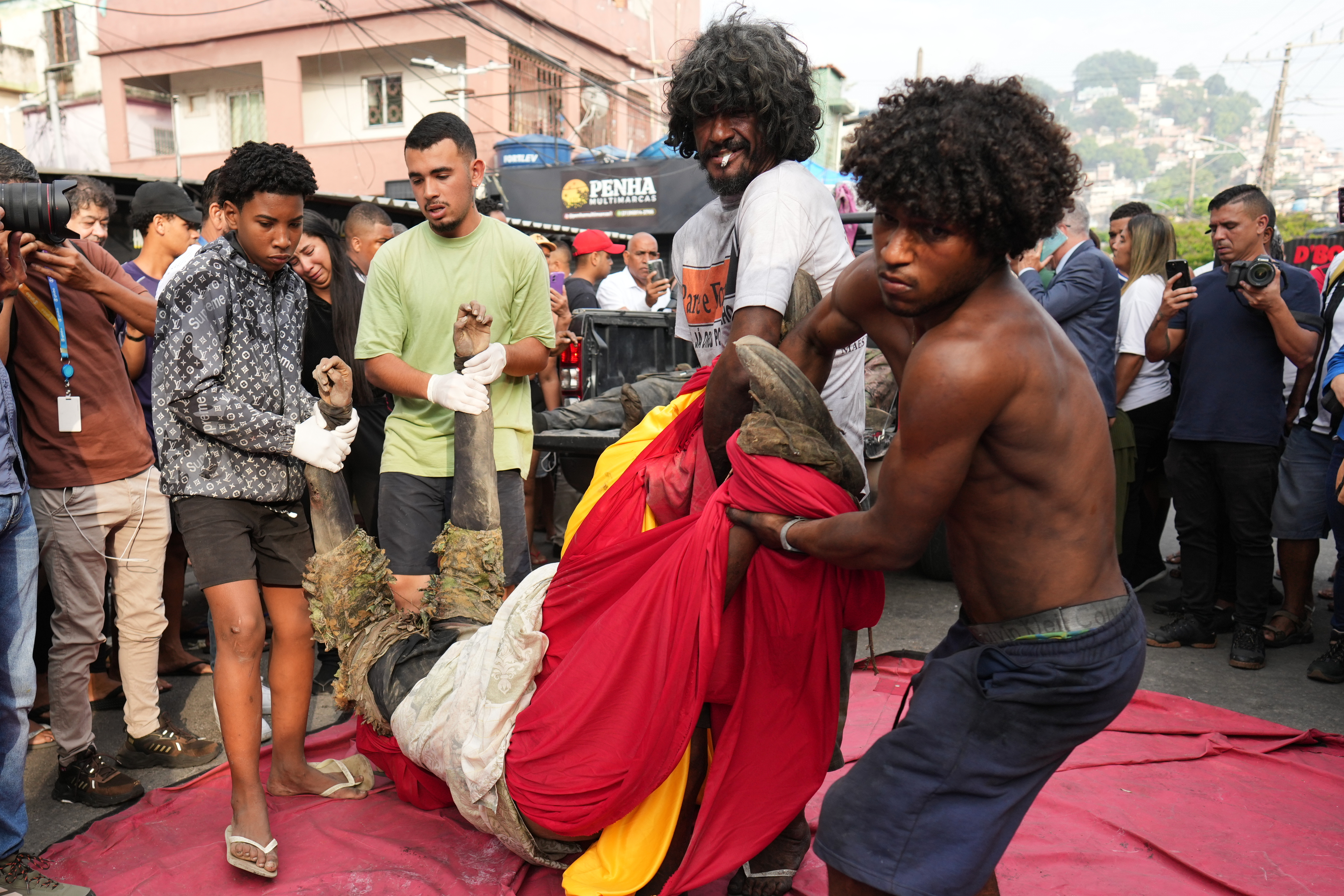 Resident carry the body of a man killed during a police raid targeting the Comando Vermelho gang in the Complexo da Penha favela of Rio de Janeiro, Brazil, Wednesday, Oct. 29, 2025. (AP Photo/Silvia Izquierdo)
