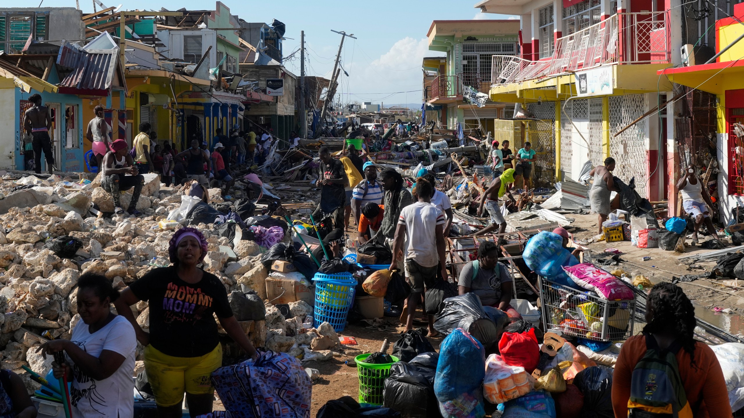 Residents gather amid debris in the aftermath of Hurricane Melissa on a street in Black River, Jamaica, Thursday, Oct. 30, 2025. (AP Photo/Matias Delacroix)