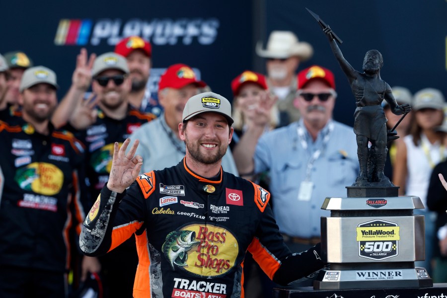 Chase Briscoe, center, celebrates with the trophy after winning a NASCAR Cup Series auto race at Talladega Superspeedway, Sunday, Oct. 19, 2025, in Talladega, Ala. (AP Photo/Butch Dill)