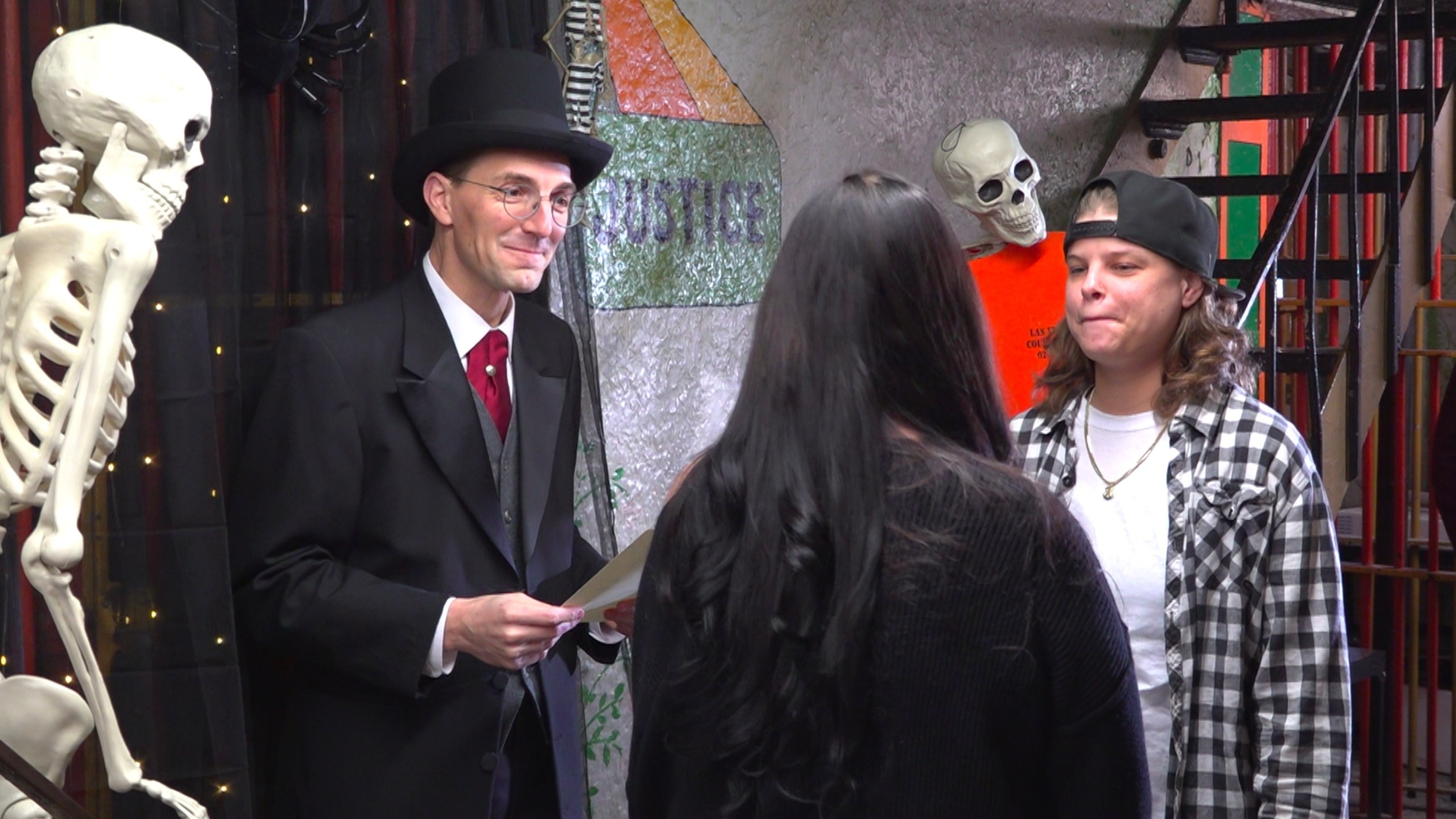 This photo taken from video shows Judge David Hejmanowski, back left, officiating the wedding of Andrea Bates, center, and Jessica Scales at the Historic Jail and Sheriff's Residence on Friday, Oct. 31, 2025, in Delaware, Ohio. (AP Photo/Patrick Aftoora-Orsagos)