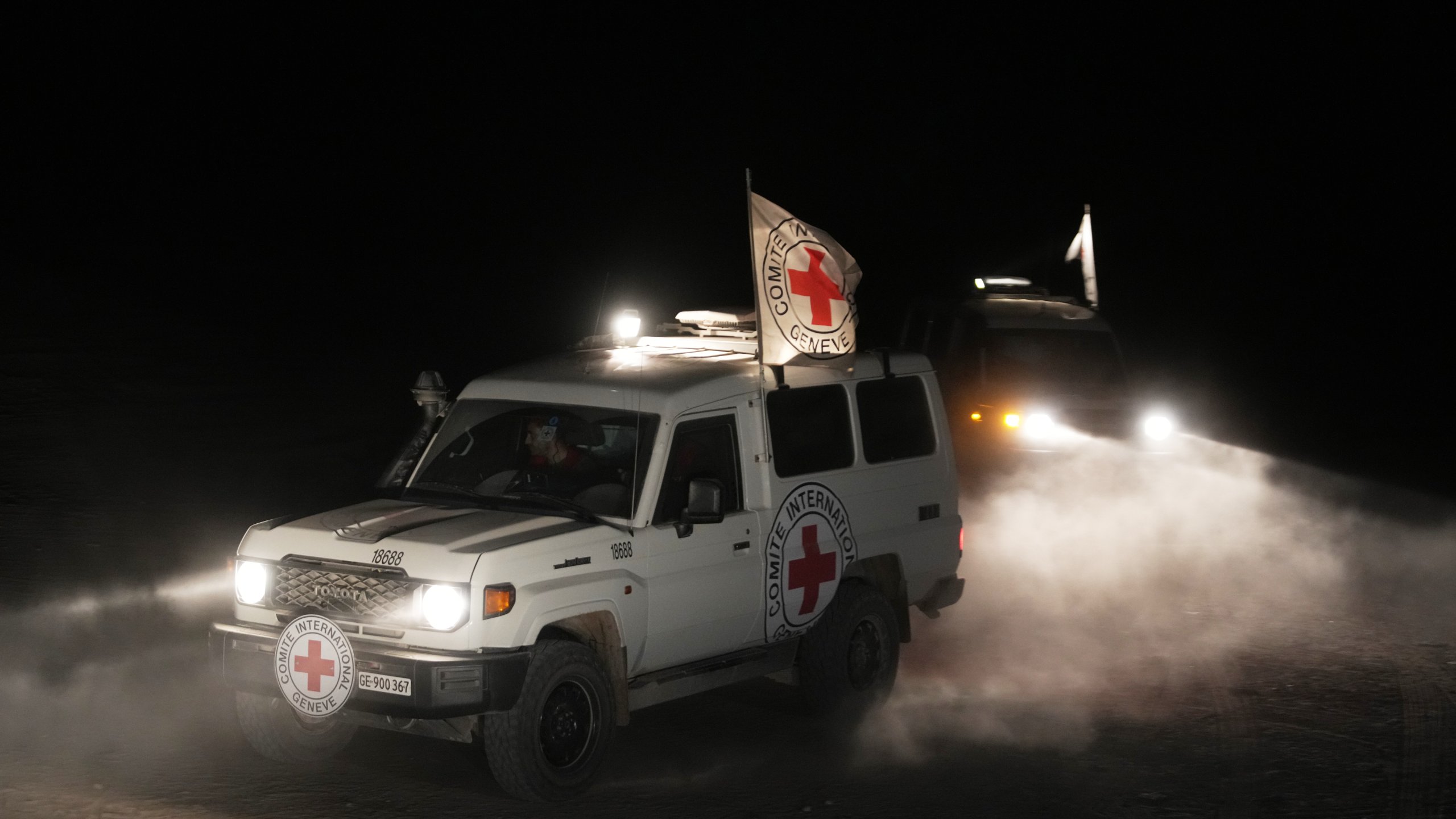 Red Cross vehicles carrying the bodies of three people believed to be deceased hostages handed over by Hamas make their way toward the border crossing with Israel, to be transferred to Israeli authorities, in Deir al-Balah, central Gaza Strip, Sunday, Nov. 2, 2025. (AP Photo/Jehad Alshrafi)
