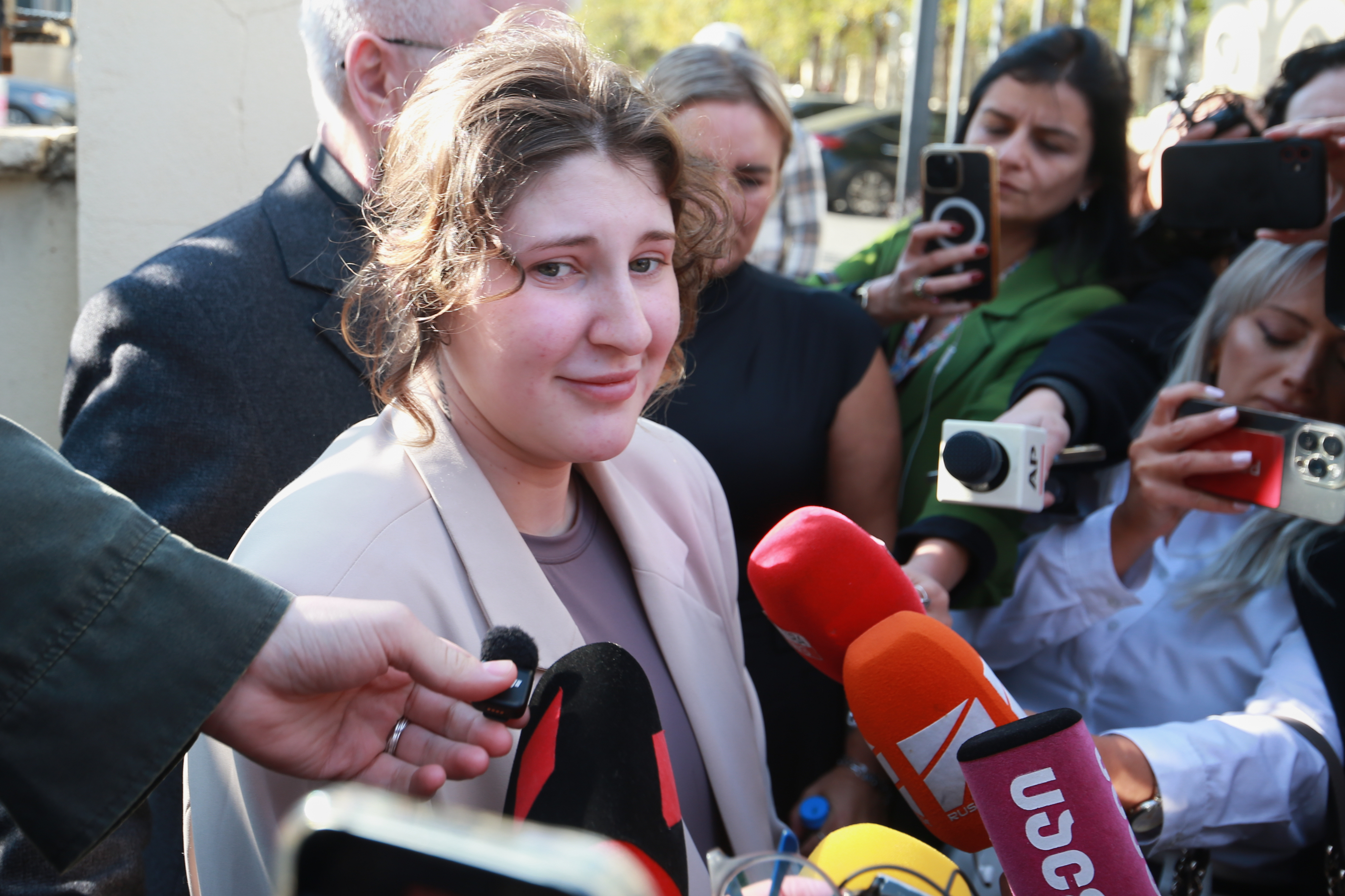 Bella May Culley, front left, 19-year-old, who was arrested upon arrival at the Tbilisi Airport in May and accused of attempting to smuggle marijuana and hashish into the country, speaks to journalists after she was released from prison near the court building in Tbilisi, Georgia, on Monday, Nov. 3, 2025, as her mother Lyanne Kennedy, stands behind. (AP Photo/Zurab Tsertsvadze)