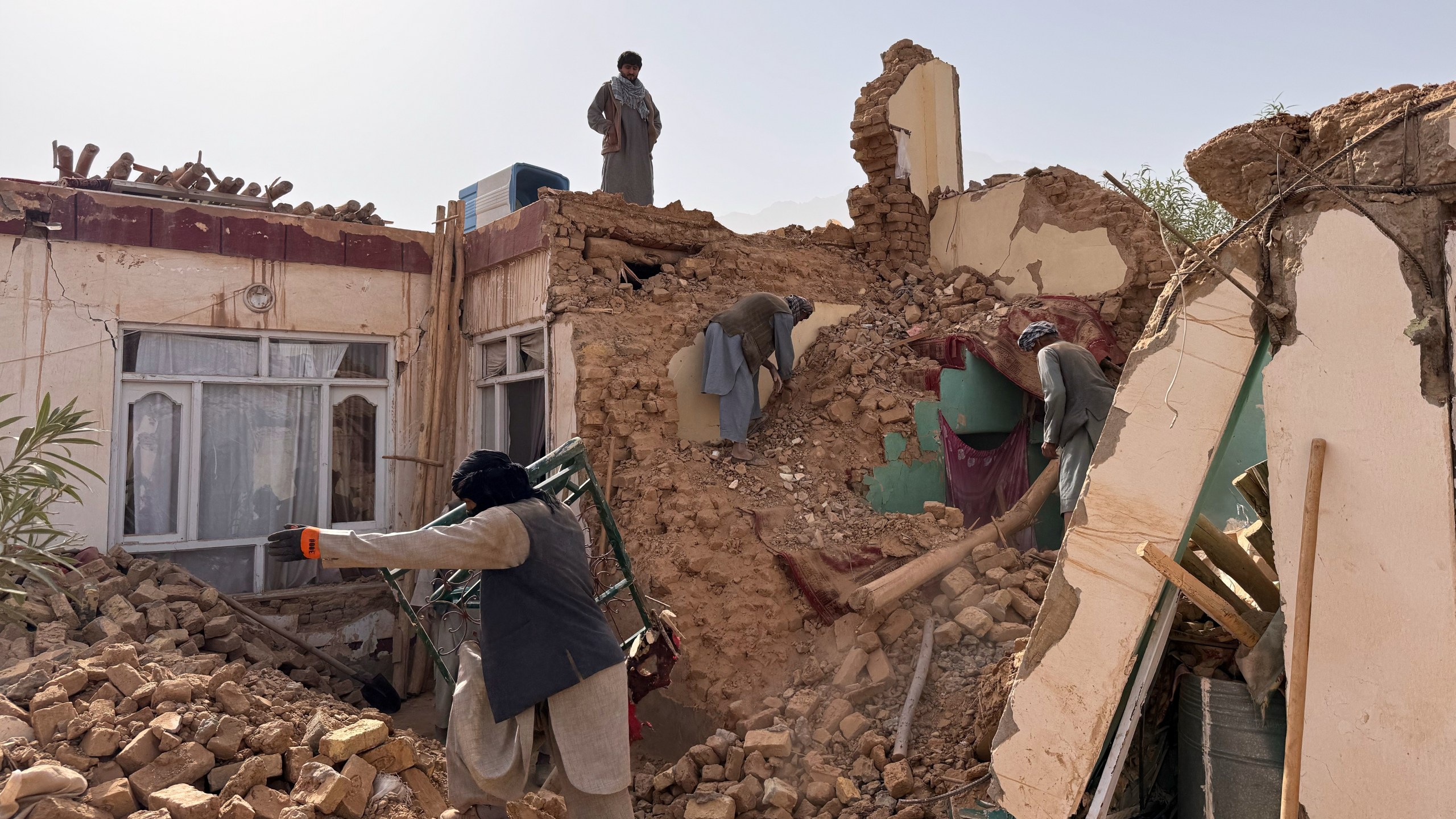 Locals search among the rubble of a destroyed house after a 6.3 powerful in a rural area of the Khulm District, Samangan Province, northern Afghanistan, Monday, Nov. 3, 2025.(AP Photo/Sirat Noori)