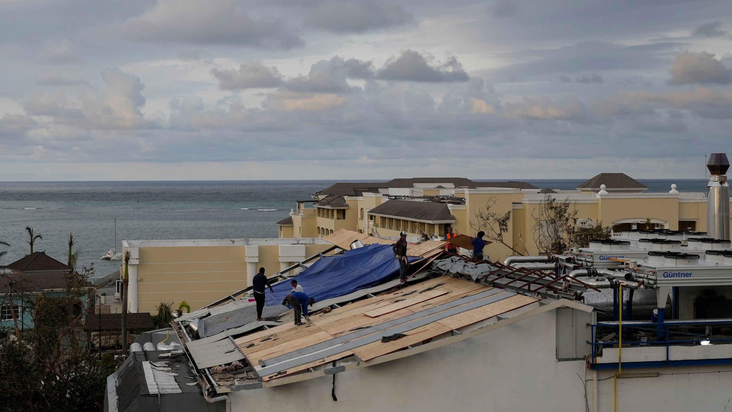 People repair the roof of a resort in Montego Bay, Jamaica, Friday, Oct. 31, 2025, in the aftermath of Hurricane Melissa. (AP Photo/Matias Delacroix)