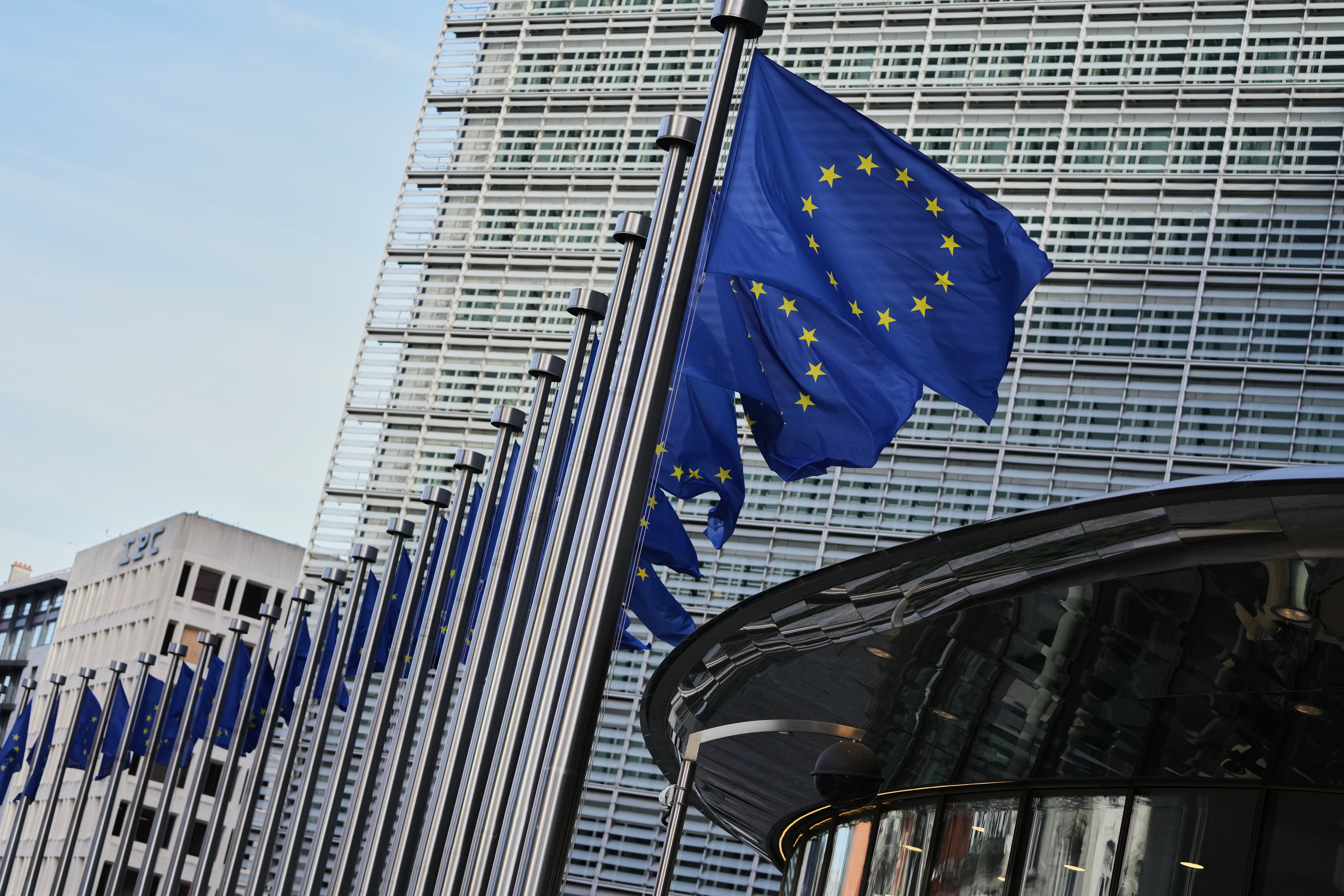 European Union flags flap in the wind outside of EU headquarters in Brussels, Tuesday, Nov. 4, 2025. (AP Photo/Virginia Mayo)