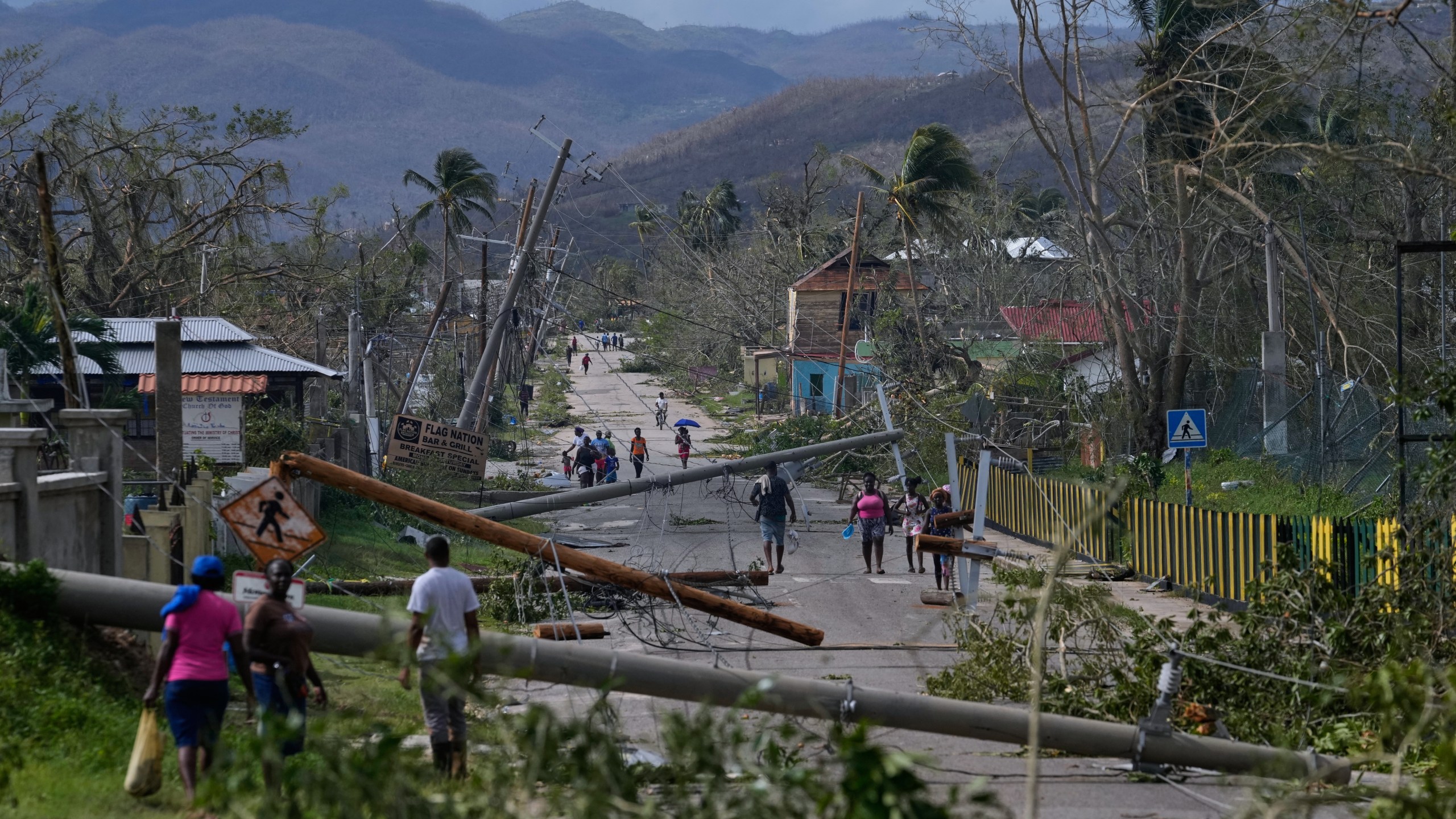 FILE - Residents walk through Lacovia Tombstone, Jamaica, in the aftermath of Hurricane Melissa, Wednesday, Oct. 29, 2025. (AP Photo/Matias Delacroix, File)