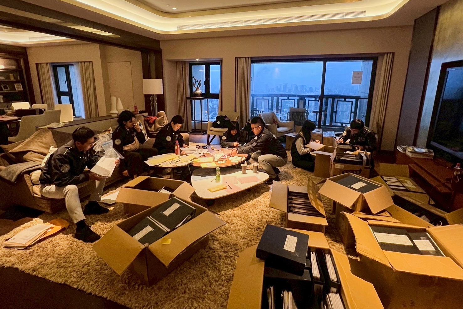 In this photo released by Ministry of Justice Investigation Bureau, Investigation Bureau agents check documents after they seized an apartment which belongs to the suspected head of a criminal scamming syndicate, in Taipei, Taiwan, Tuesday, Nov. 4, 2025. (Ministry of Justice Investigation Bureau via AP)