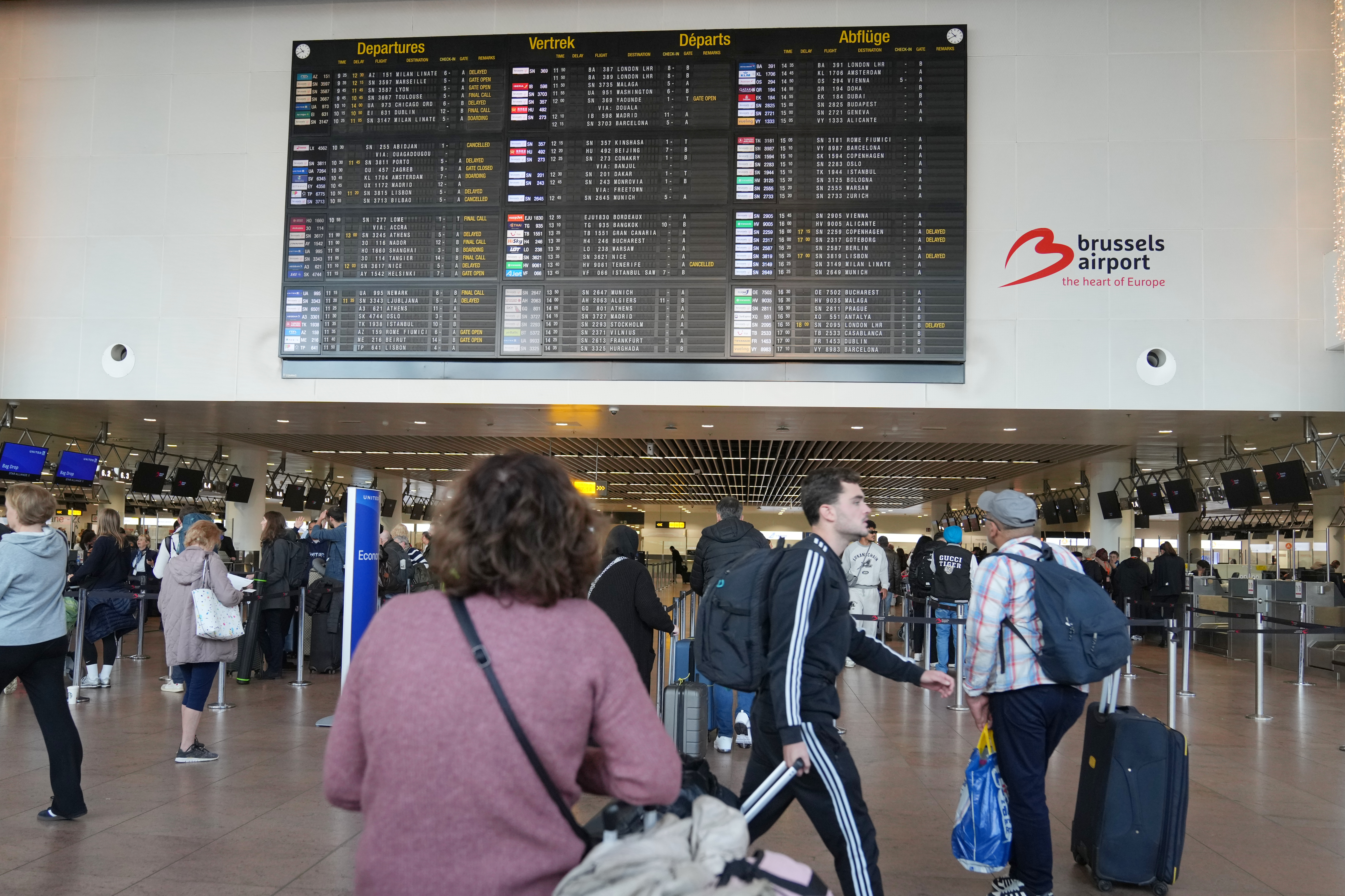 A passenger looks at a departures board after several cancellations and delays due to reported overnight drone activity over Brussels International Airport in Zaventem, Wednesday, Nov. 5, 2025. (AP Photo/Virginia Mayo)