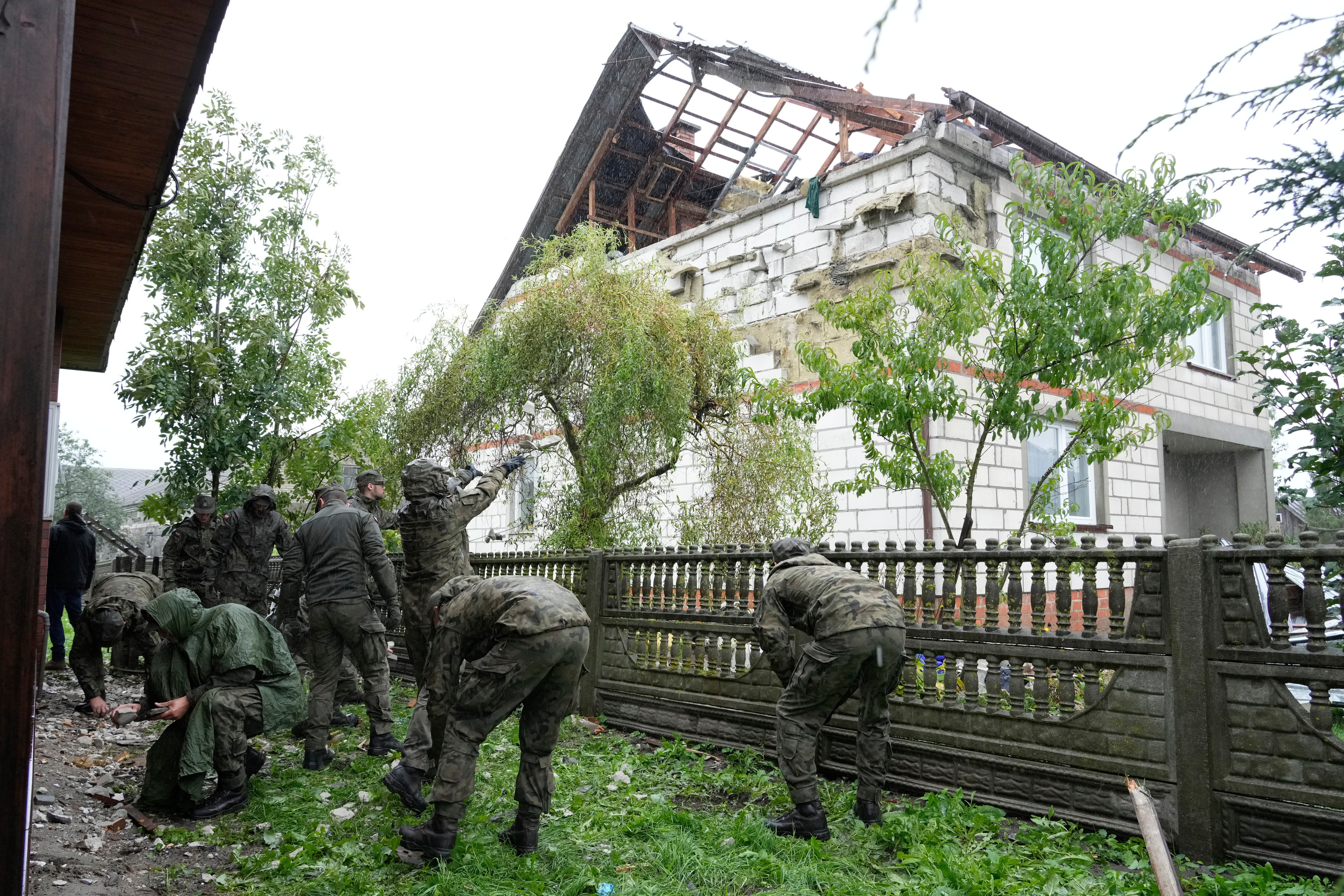 FILE - Territorial defense officers clean up debris from the destroyed roof of a house in Wyryki near Lublin, Poland, after Russian drones violated Polish airspace during an attack on Ukraine, on Sept. 11, 2025. (AP Photo/Czarek Sokolowski, File)