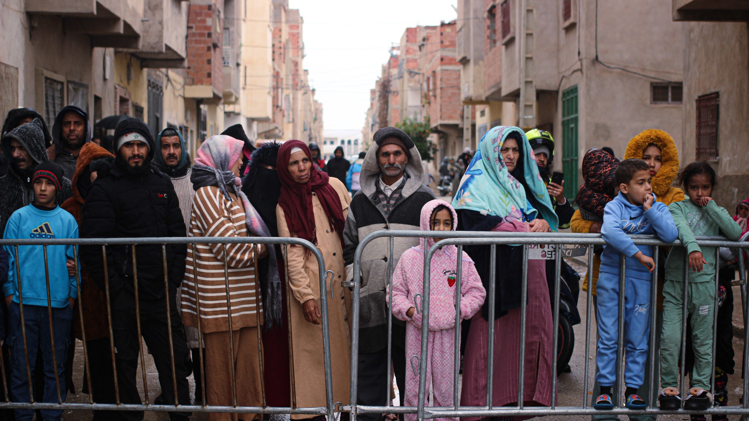 Residents watch as rescue workers search for survivors, amid the wreckage of two collapsed buildings, in Fez, Morocco, Wednesday, Dec. 10, 2025. (AP Photo/Hanane Boukili)