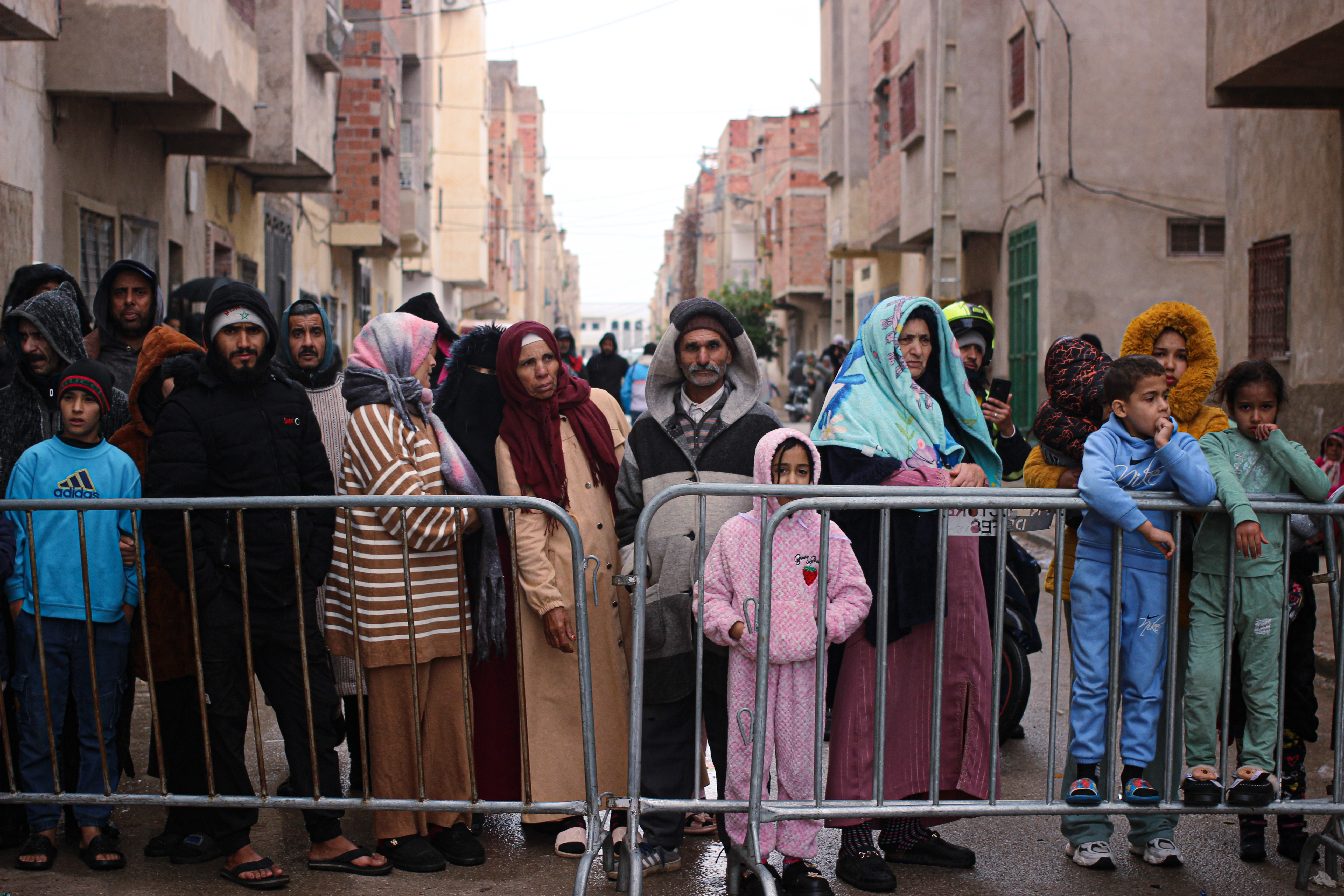 Residents watch as rescue workers search for survivors, amid the wreckage of two collapsed buildings, in Fez, Morocco, Wednesday, Dec. 10, 2025. (AP Photo/Hanane Boukili)