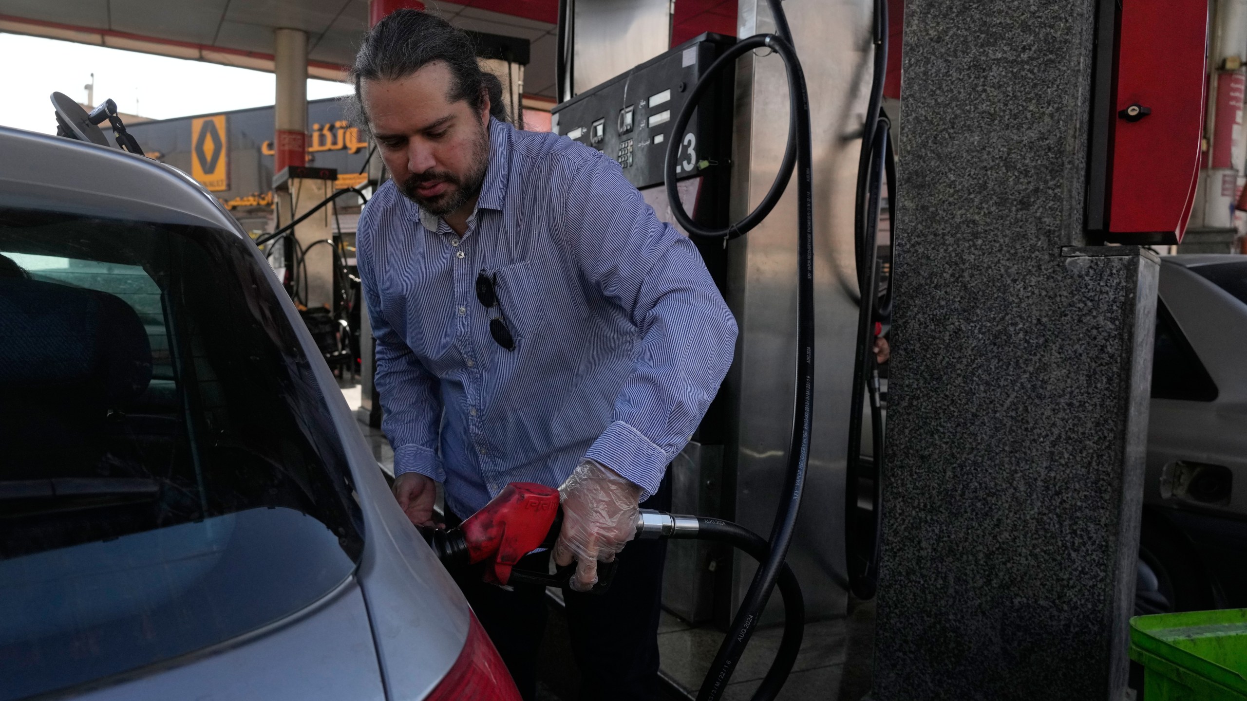 A man fills his car at a gas station in Tehran, Iran, Thursday, Nov. 27, 2025. (AP Photo/Vahid Salemi)