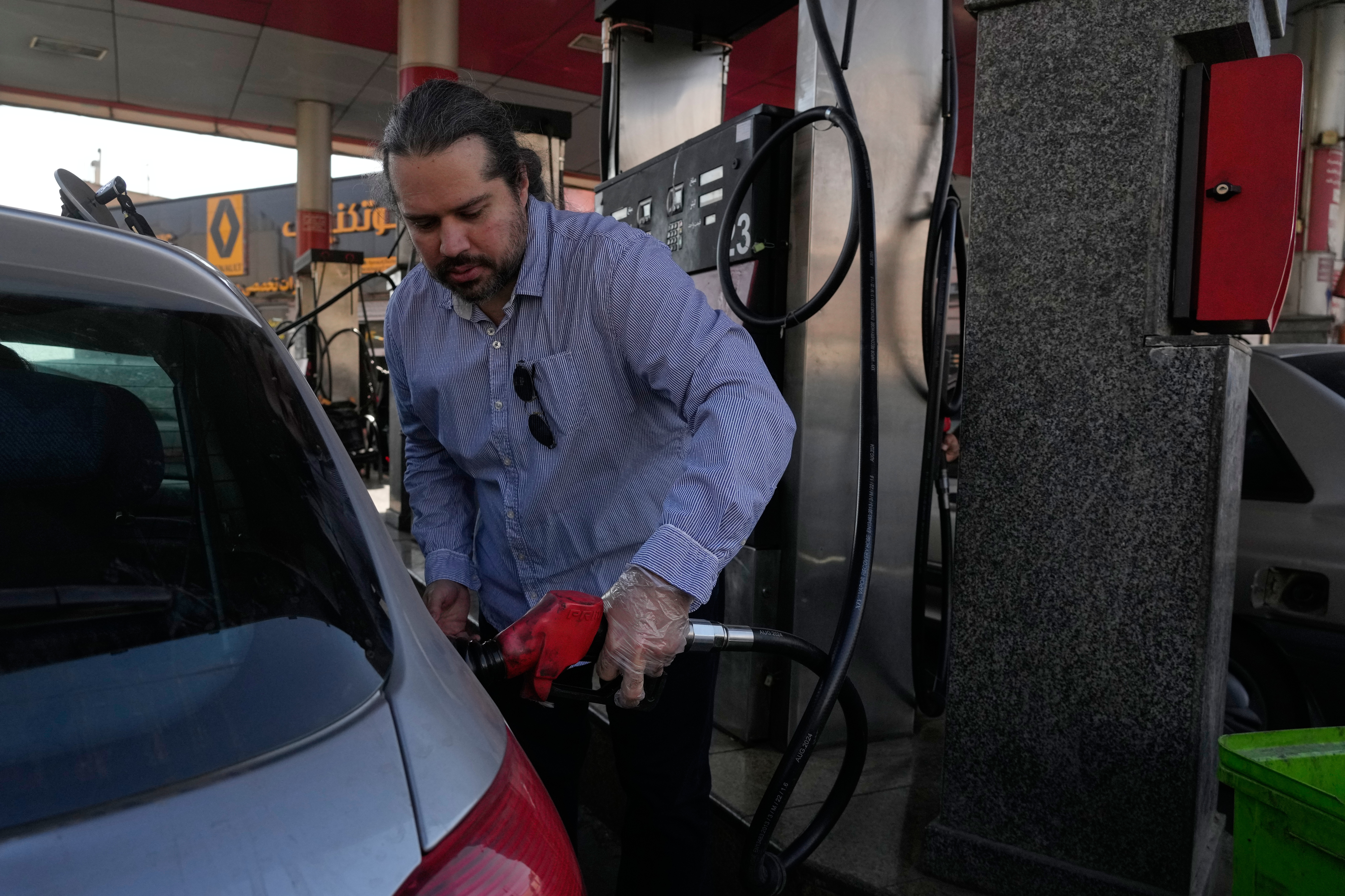 A man fills his car at a gas station in Tehran, Iran, Thursday, Nov. 27, 2025. (AP Photo/Vahid Salemi)