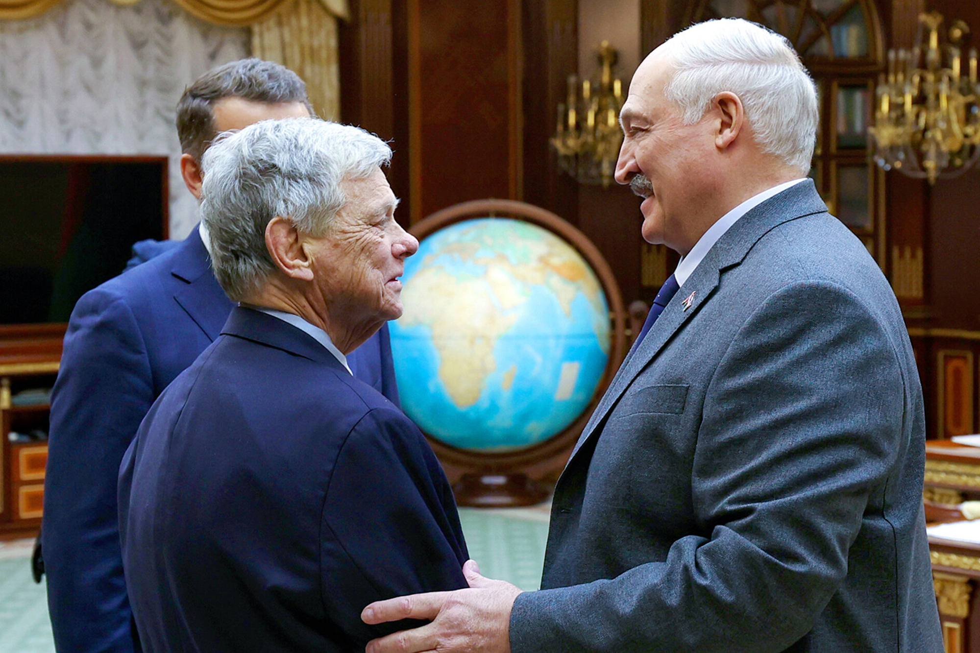 In this photo released by Belarusian presidential press service, Belarusian President Alexander Lukashenko, right, and U.S. Presidential envoy John Coale shake hands during their meeting in Minsk, Belarus, Friday, Dec. 12, 2025. (Belarusian Presidential Press Service via AP)