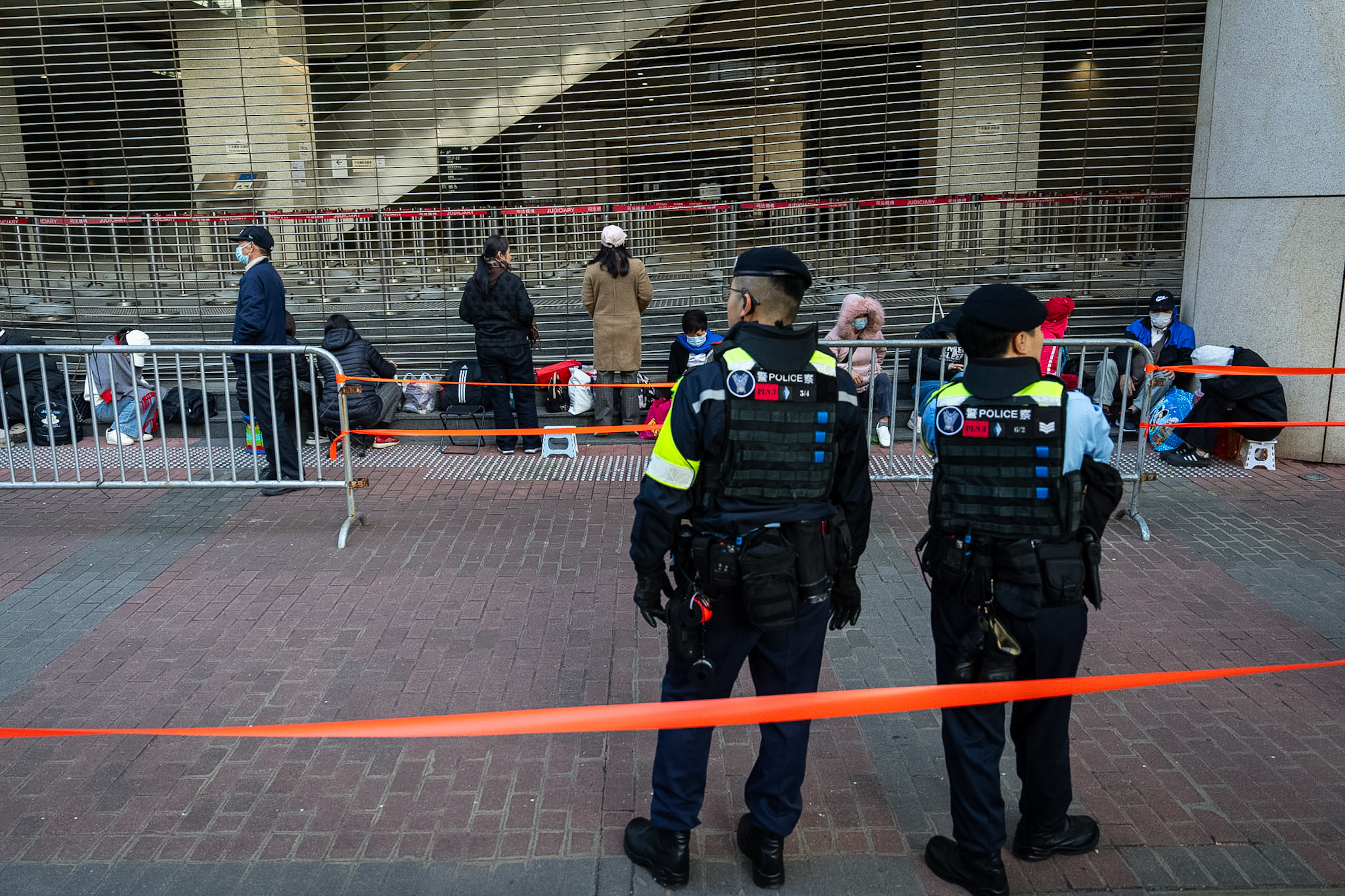 People wait to enter the West Kowloon Magistrates' Courts ahead of the verdict for Hong Kong activist publisher Jimmy Lai's national security trial, in Hong Kong, Monday, Dec. 15, 2025. (AP Photo/Chan Long Hei)