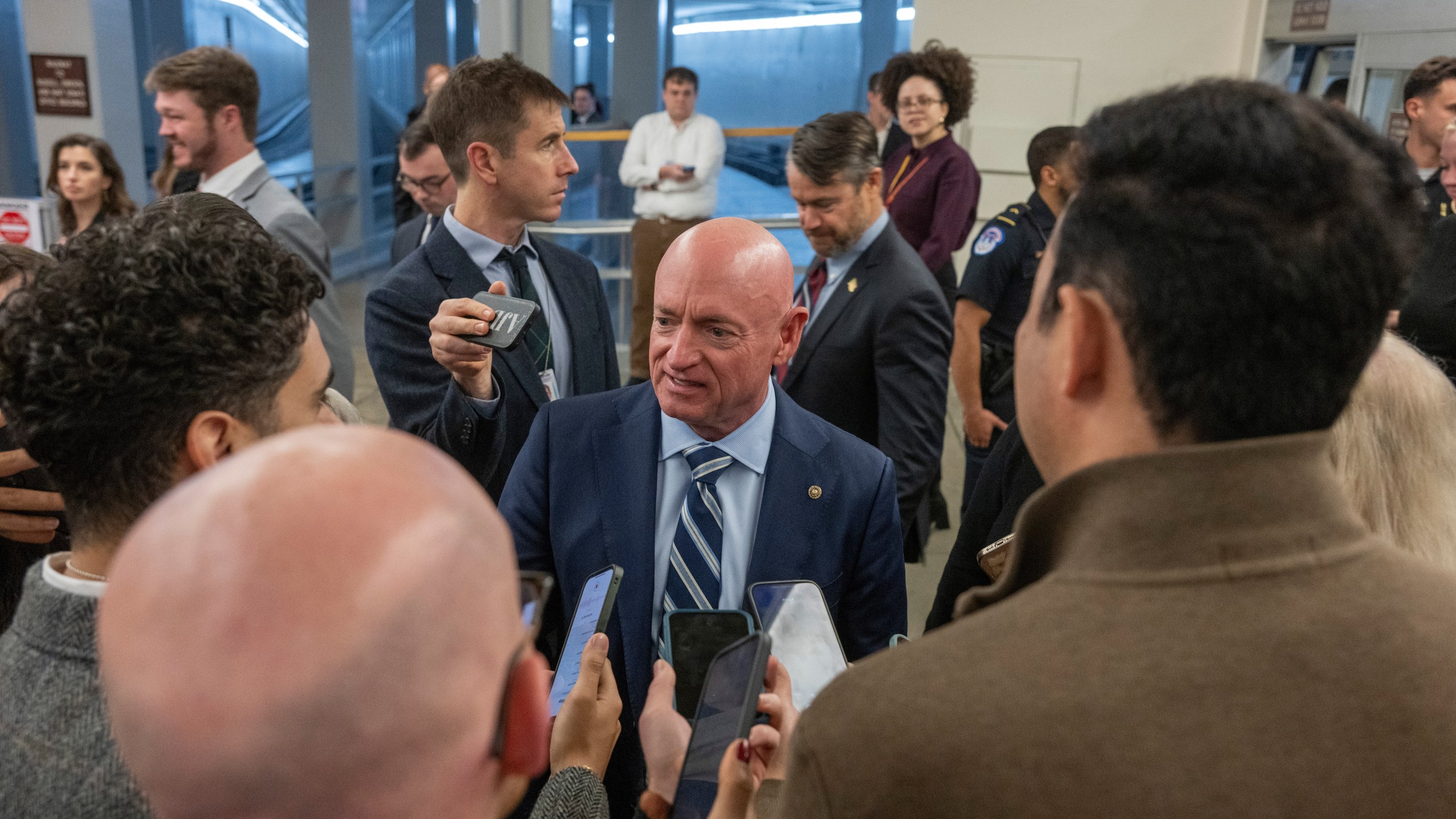Sen. Mark Kelly, D-Ariz, speaks to reporters near the Senate Subway stakeout, Thursday, Dec. 4, 2025 in Washington. (AP Photo/Kevin Wolf)