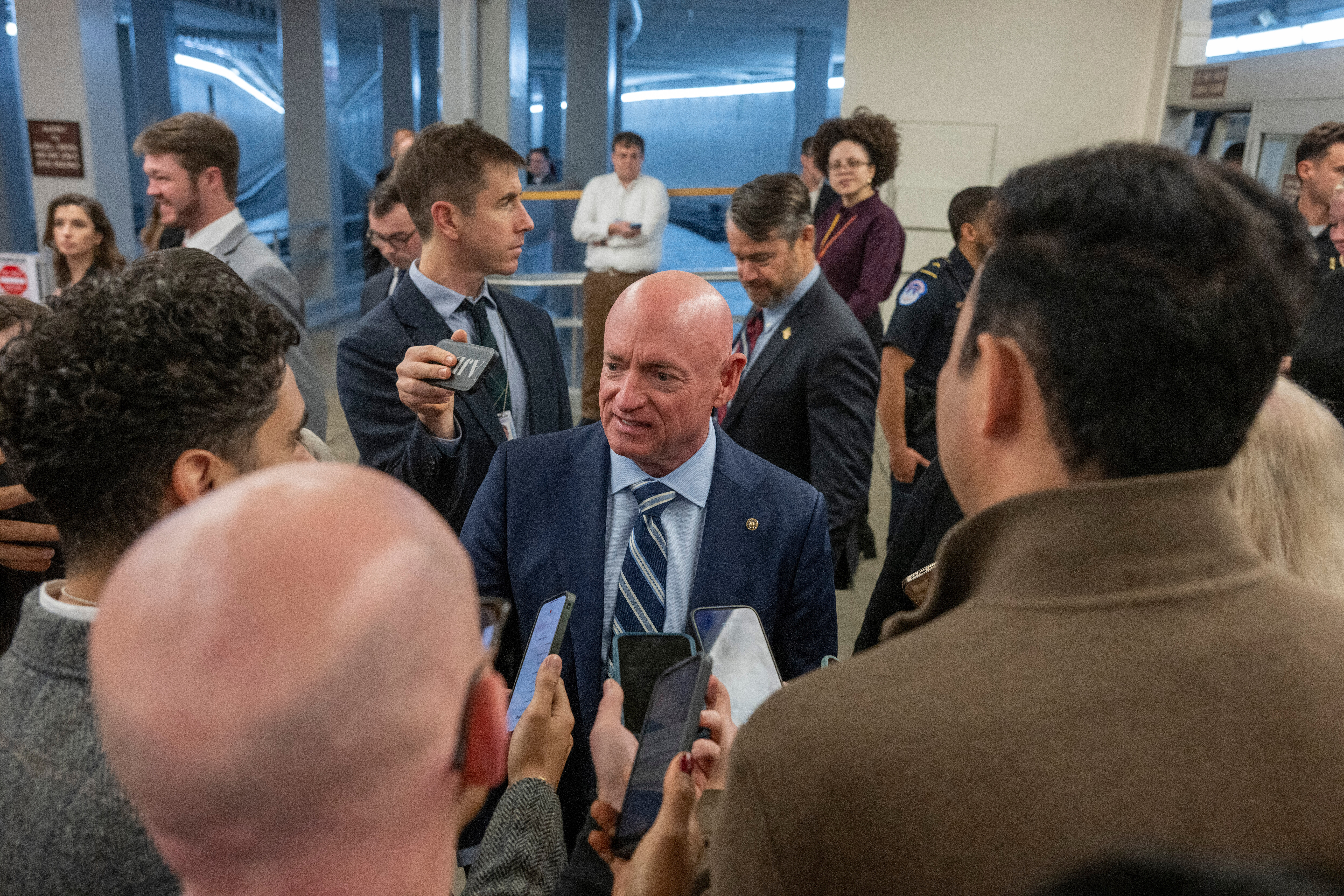 Sen. Mark Kelly, D-Ariz, speaks to reporters near the Senate Subway stakeout, Thursday, Dec. 4, 2025 in Washington. (AP Photo/Kevin Wolf)