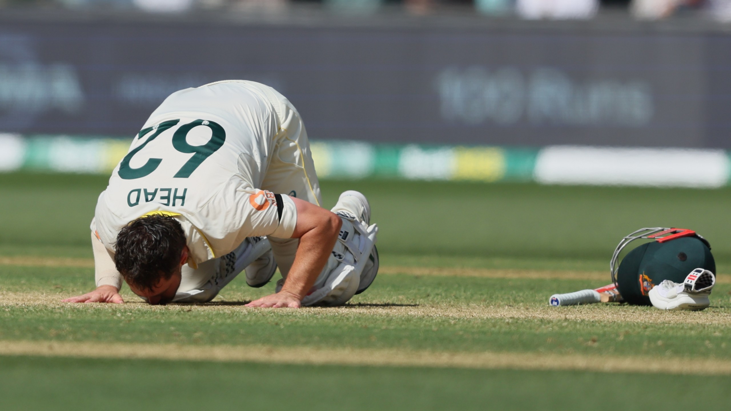 Australia's Travis Head kisses the pitch after scoring a century during play on day three of the third Ashes cricket test between England and Australia in Adelaide, Australia, Friday, Dec. 19, 2025. (AP Photo/James Elsby)