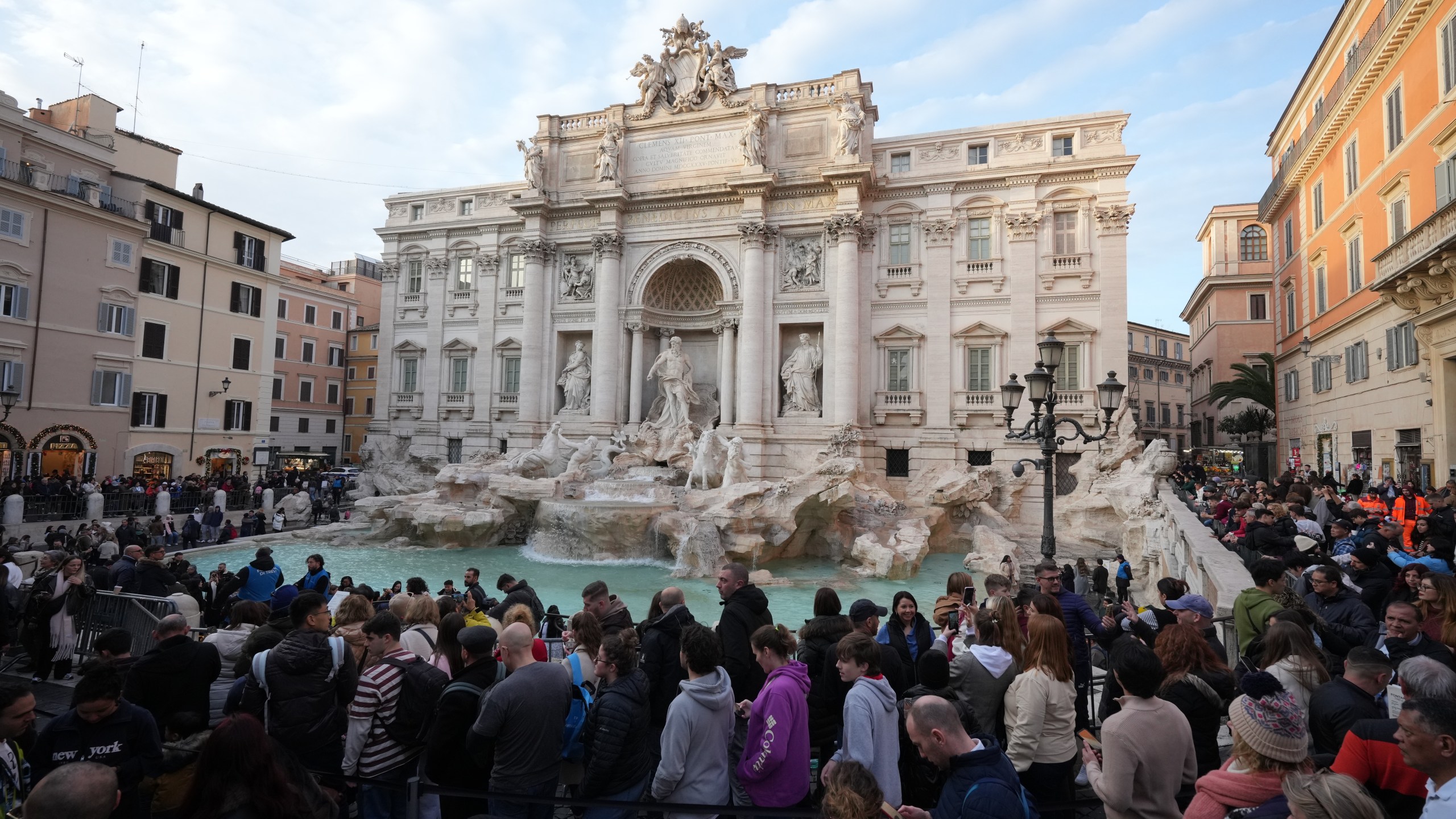 Visitors admire Rome's Trevi Fountain, Friday, Dec. 19, 2025, as the city municipality announced that, starting on Feb. 1, it will impose a 2 euro fee for tourists to visit the recessed fountain edge. (AP Photo/Andrew Medichini)