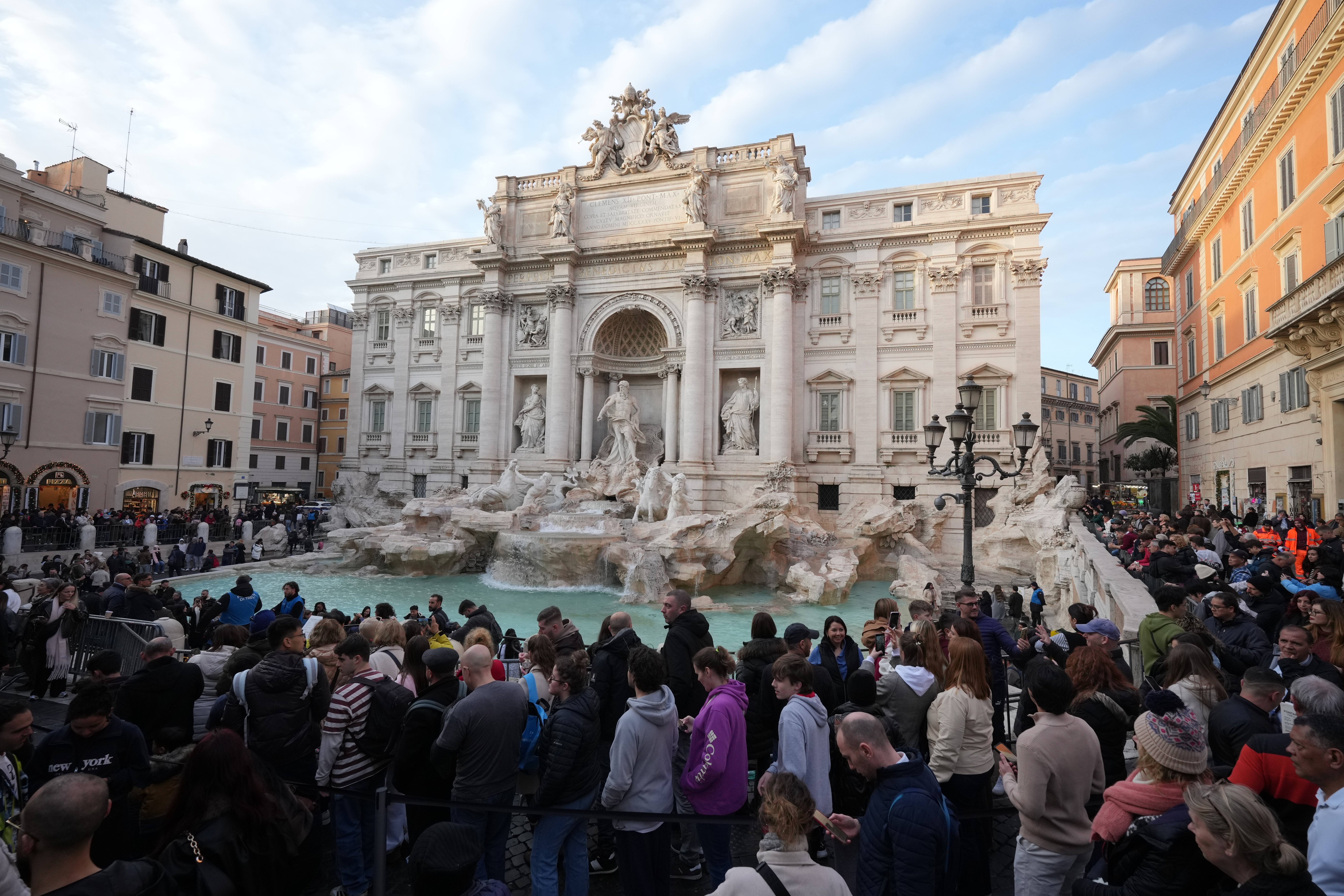 Visitors admire Rome's Trevi Fountain, Friday, Dec. 19, 2025, as the city municipality announced that, starting on Feb. 1, it will impose a 2 euro fee for tourists to visit the recessed fountain edge. (AP Photo/Andrew Medichini)