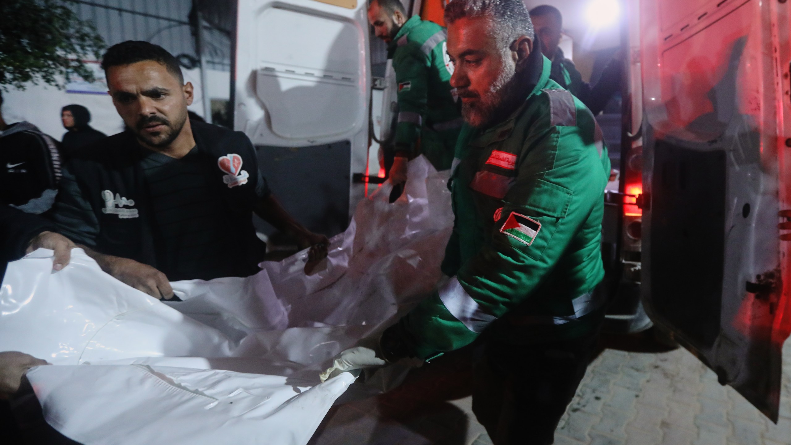 Palestinians carry the body of a person killed in an Israeli military strike as they arrive at Shifa Hospital in Gaza City, Friday, Dec. 19, 2025. (AP Photo/Yousef Al Zanoun)