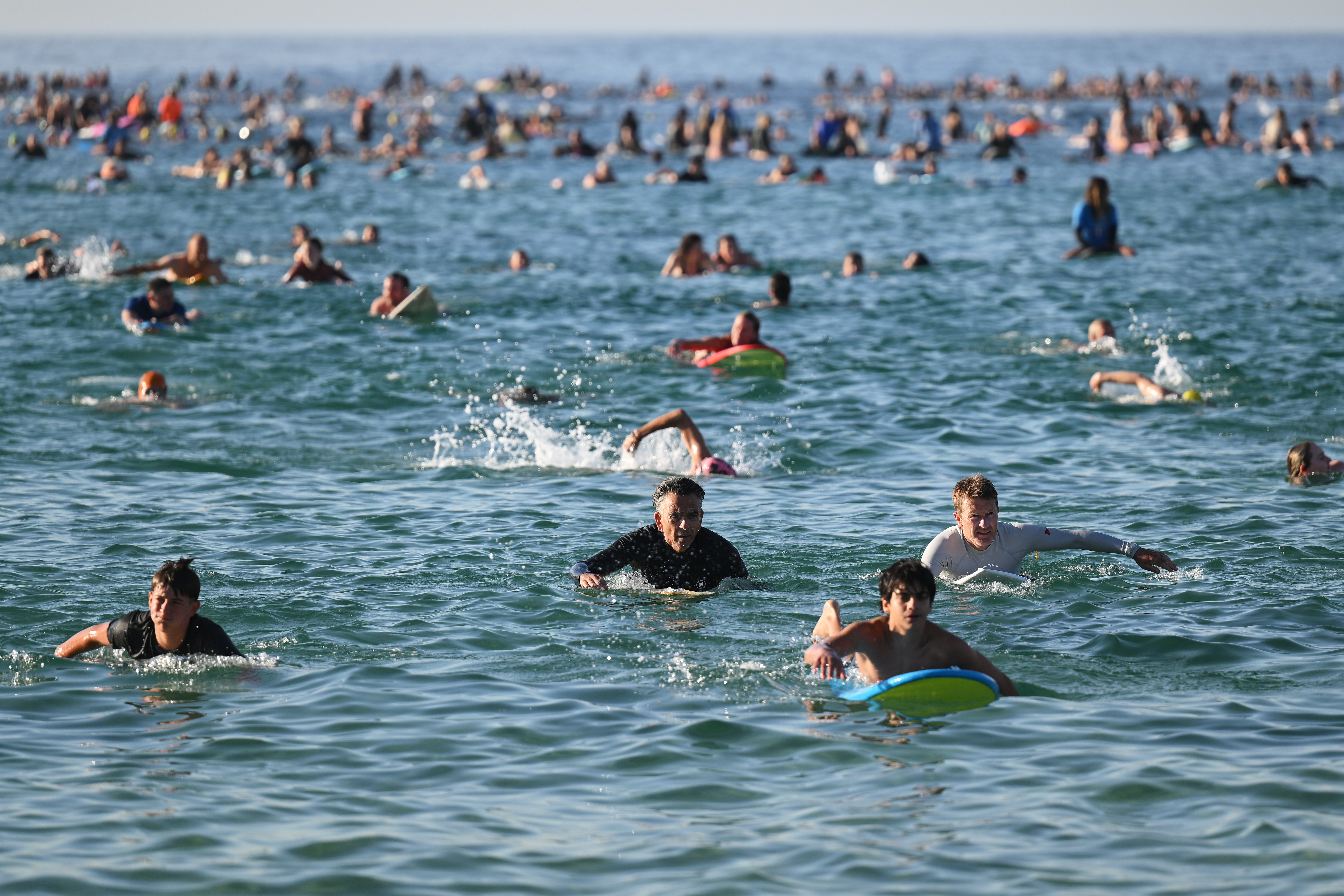 FILE - Surfers and swimmers head out to the ocean as a tribute following Sunday's shooting at Bondi Beach, in Sydney, Friday, Dec. 19, 2025. (AP Photo/Steve Markham,File)