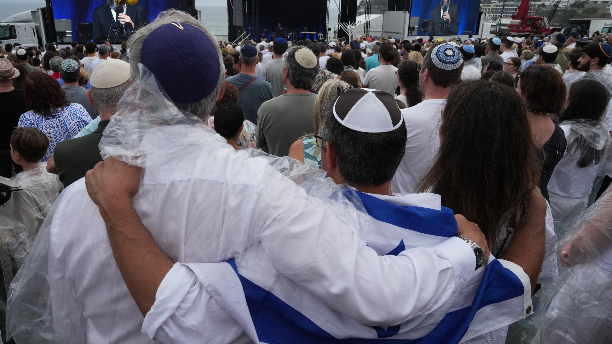 People attend a ceremony to mark the National Day of Reflection for victims and survivors, at Bondi Beach in Sydney, Sunday, Dec. 21, 2025, following the Bondi shooting on Dec. 14. (AP Photo/Mark Baker)