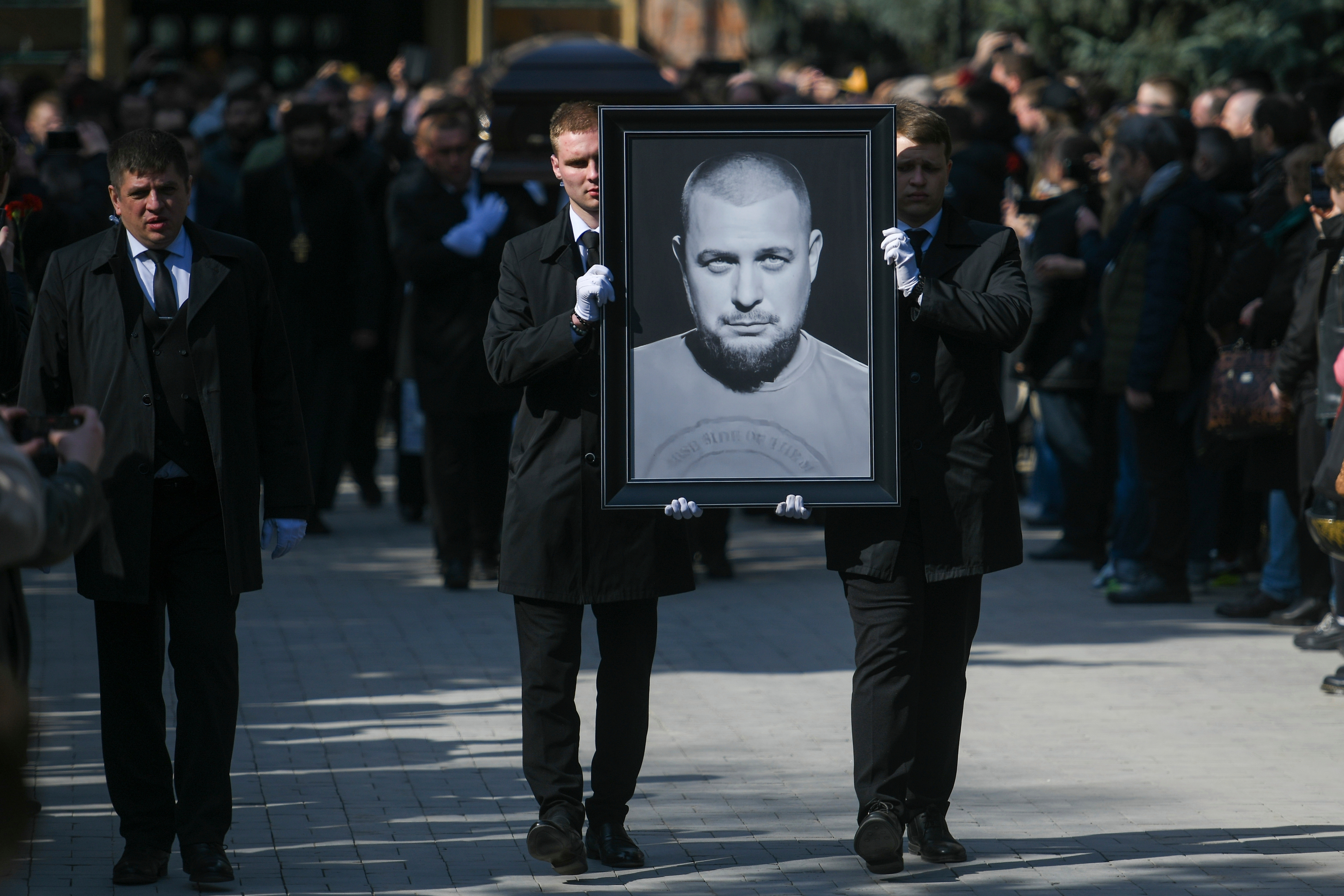 FILE - Cemetery workers carry a portrait of slain Russian military blogger Vladlen Tatarsky during a funeral at the Troyekurovskoye Cemetery in Moscow, Russia, on April 8, 2023. (Anton Velikzhanin, M24/Moscow News Agency via AP, File)