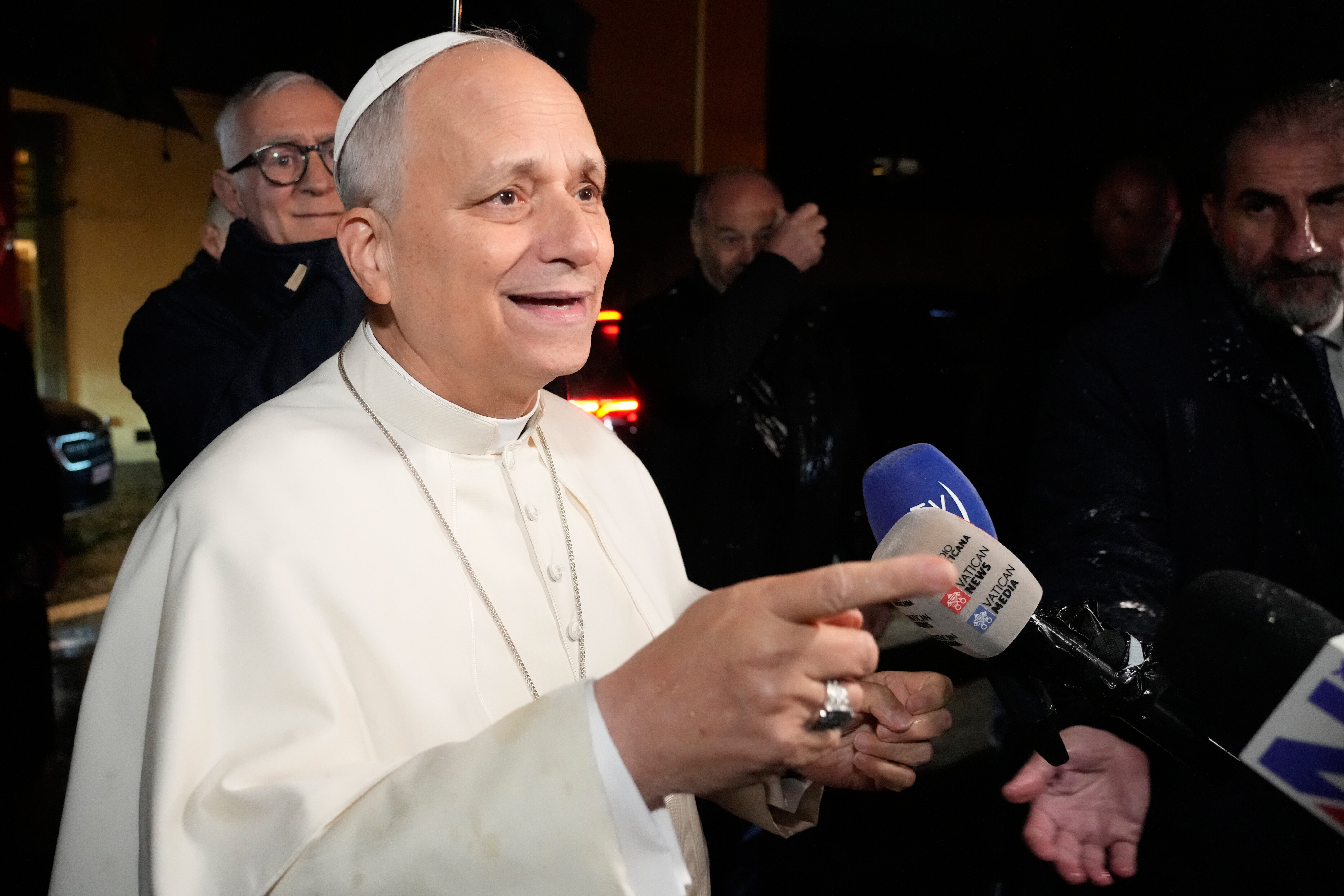 Pope Leo XIV talks to journalists as he leaves the Castel Gandolfo residence to head to the Vatican, Tuesday, Dec. 23, 2025. (AP Photo/Gregorio Borgia)