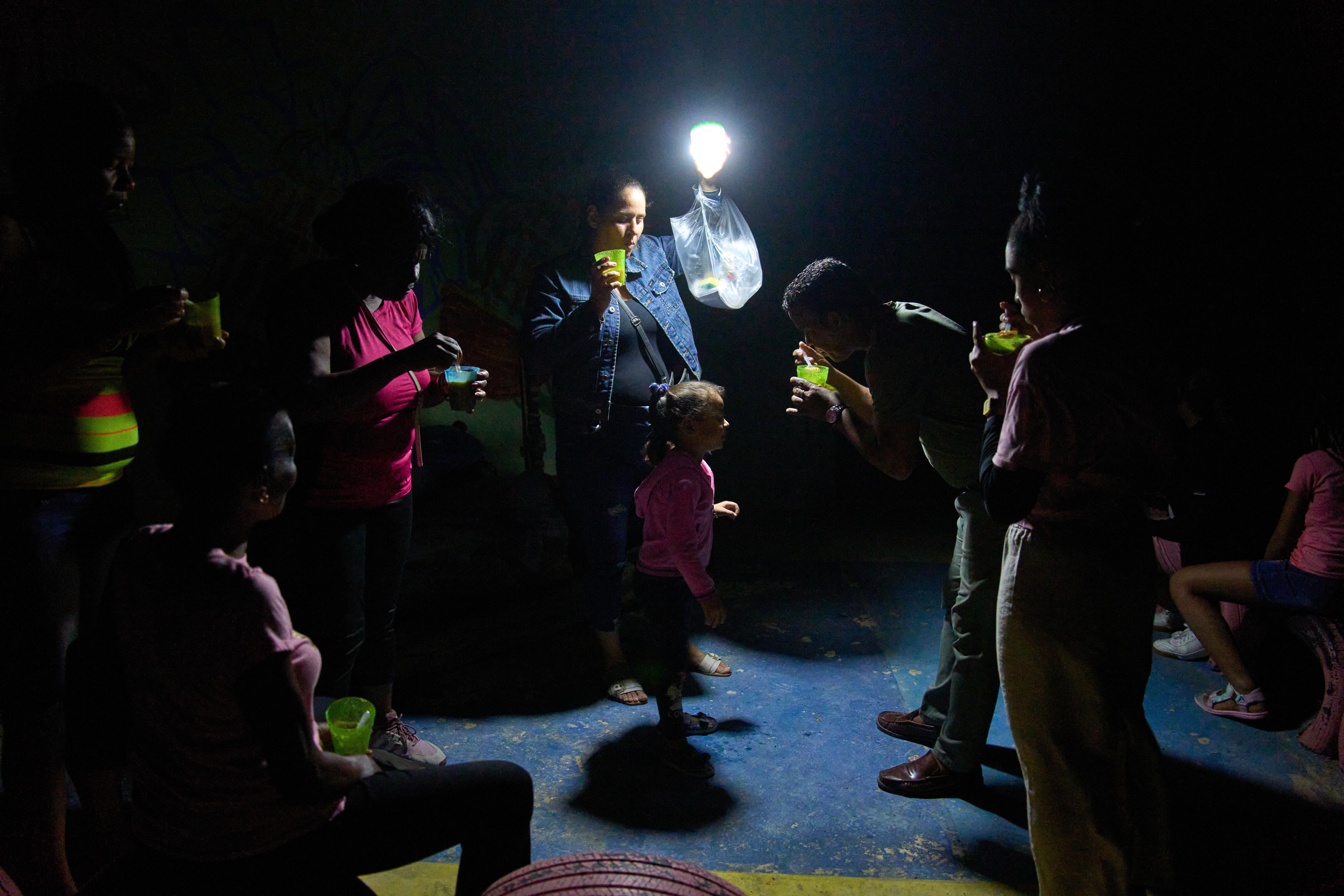 A man gives a girl a spoonful of soup on a street during a blackout in Havana, Wednesday, March 4, 2026. (AP Photo/Ramon Espinosa)