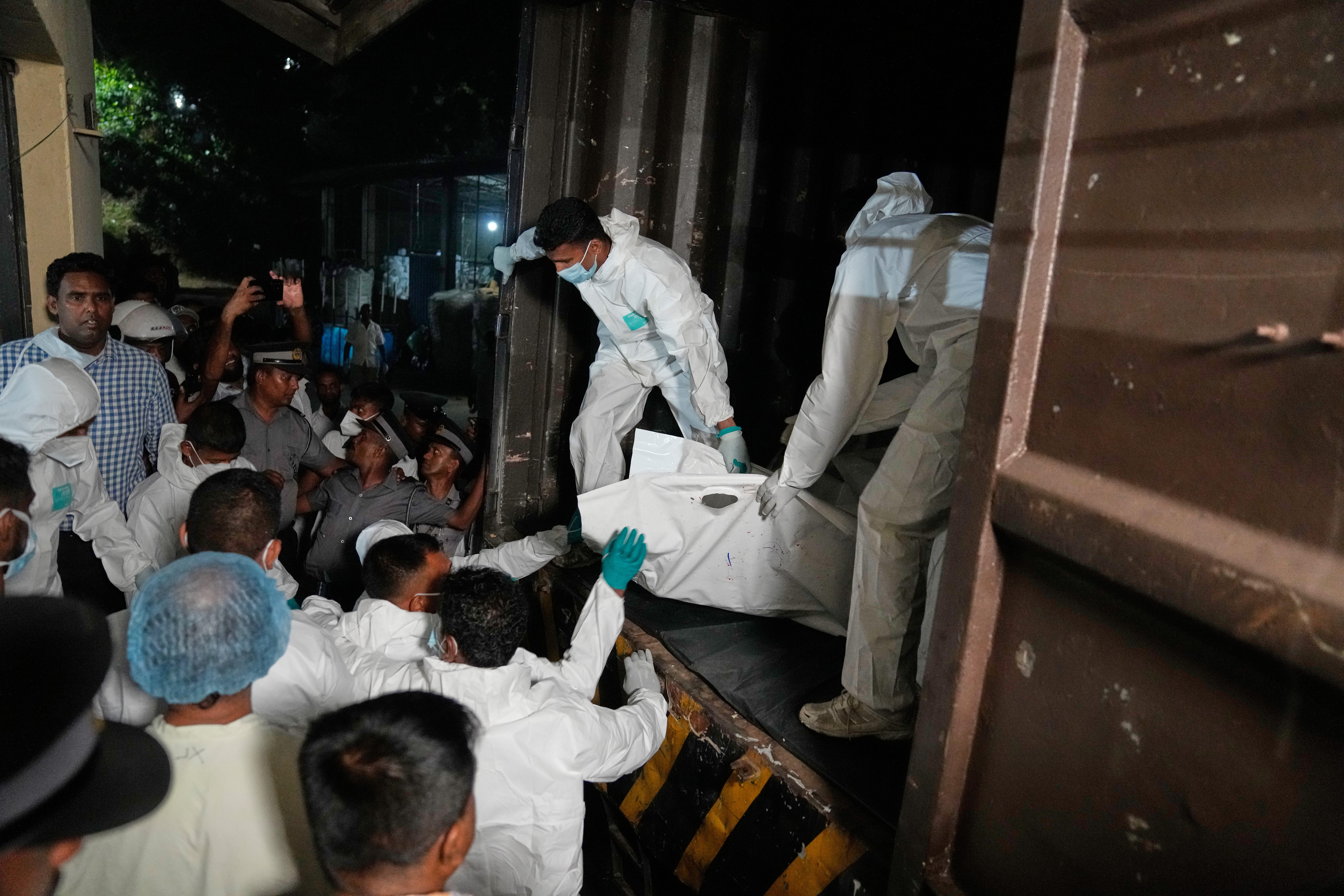 Healthcare workers unload from a vehicle, the bodies of Iranian sailors who died when their IRIS Dena warship sank outside Sri Lanka's territorial waters, in Galle, Sri Lanka, Wednesday, March 4, 2026. (AP Photo/Eranga Jayawardena)
